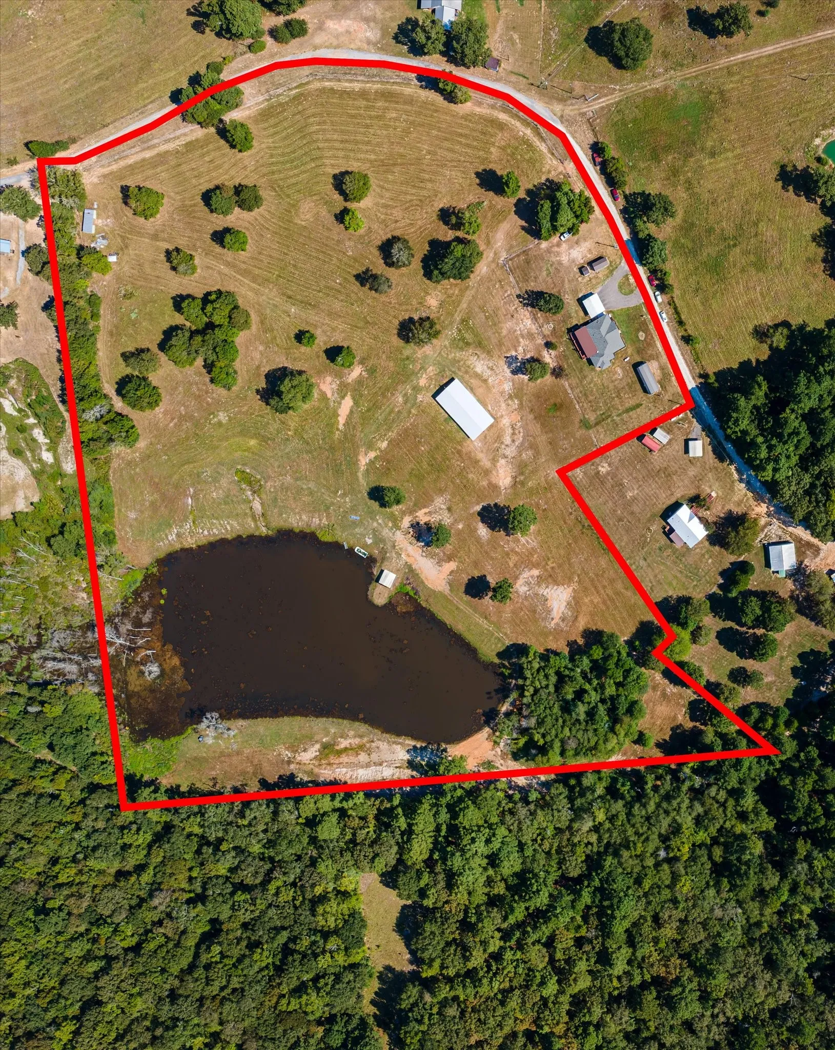 Aerial Photograph. Displaying the boundaries of the property including structures, open land, and a body of water