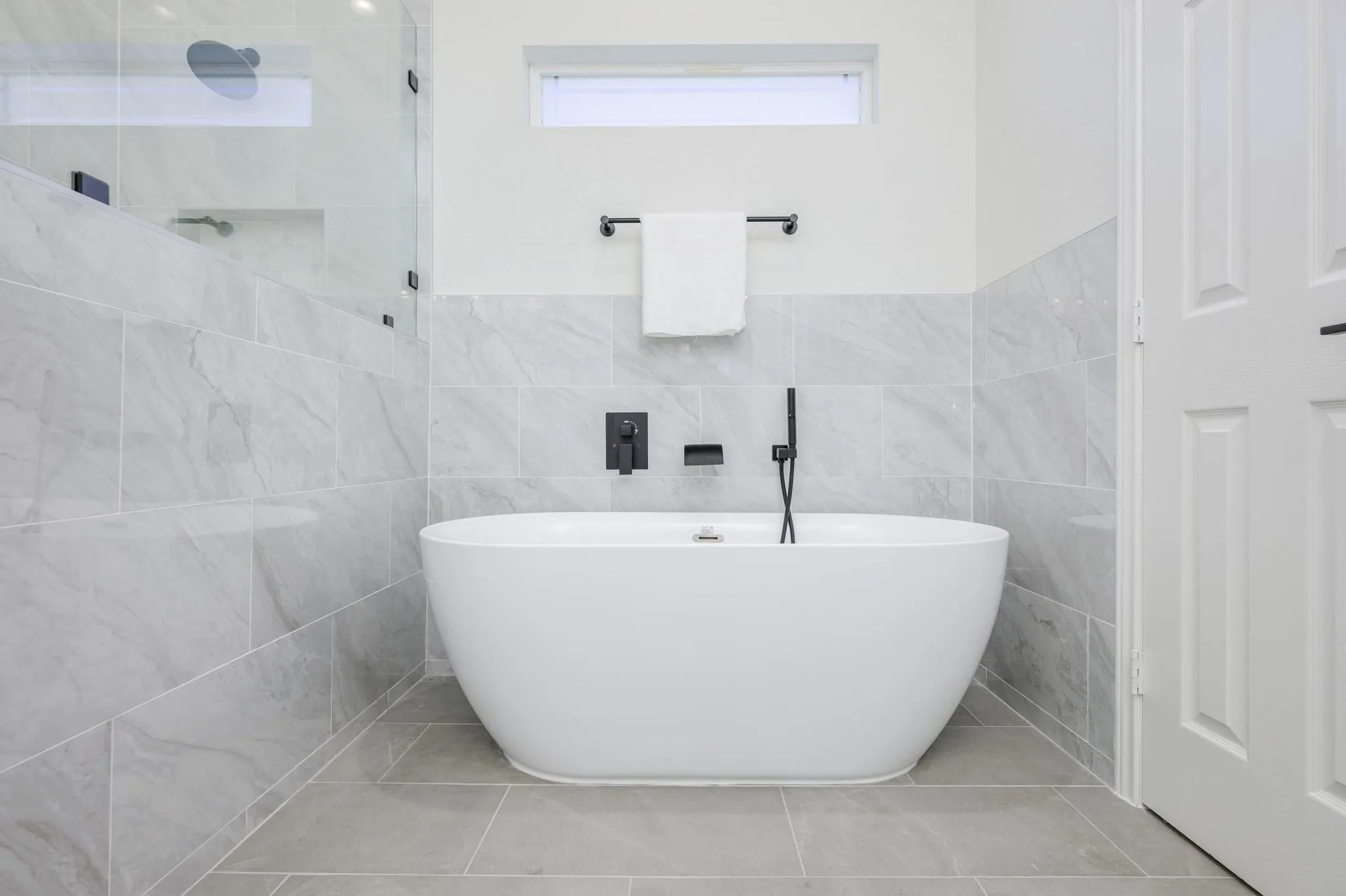 Luxurious spa-like primary bath boasting free standing soaking tub, separate shower, and dual sinks.