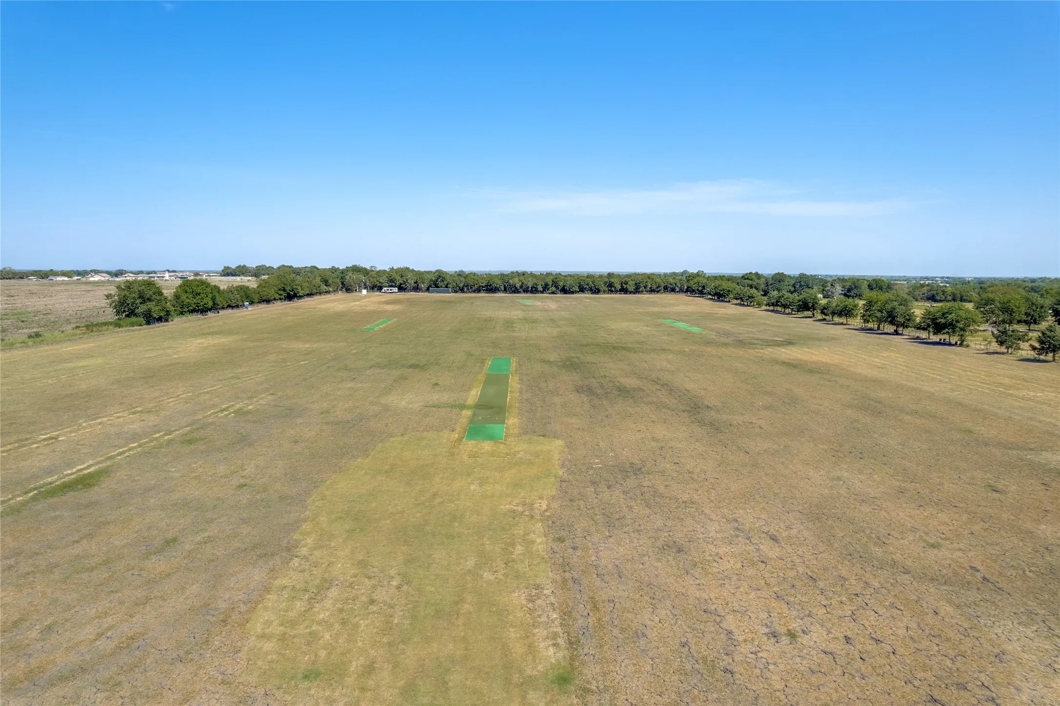 Expansive land parcel featuring open fields and distant tree lines