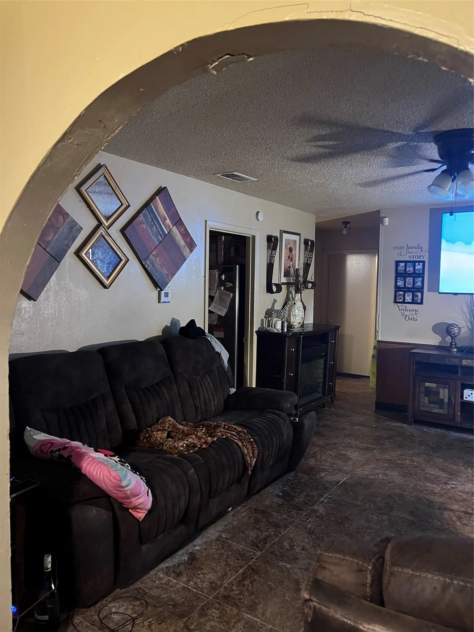 Archway entrance to a living space featuring textured walls and ceiling