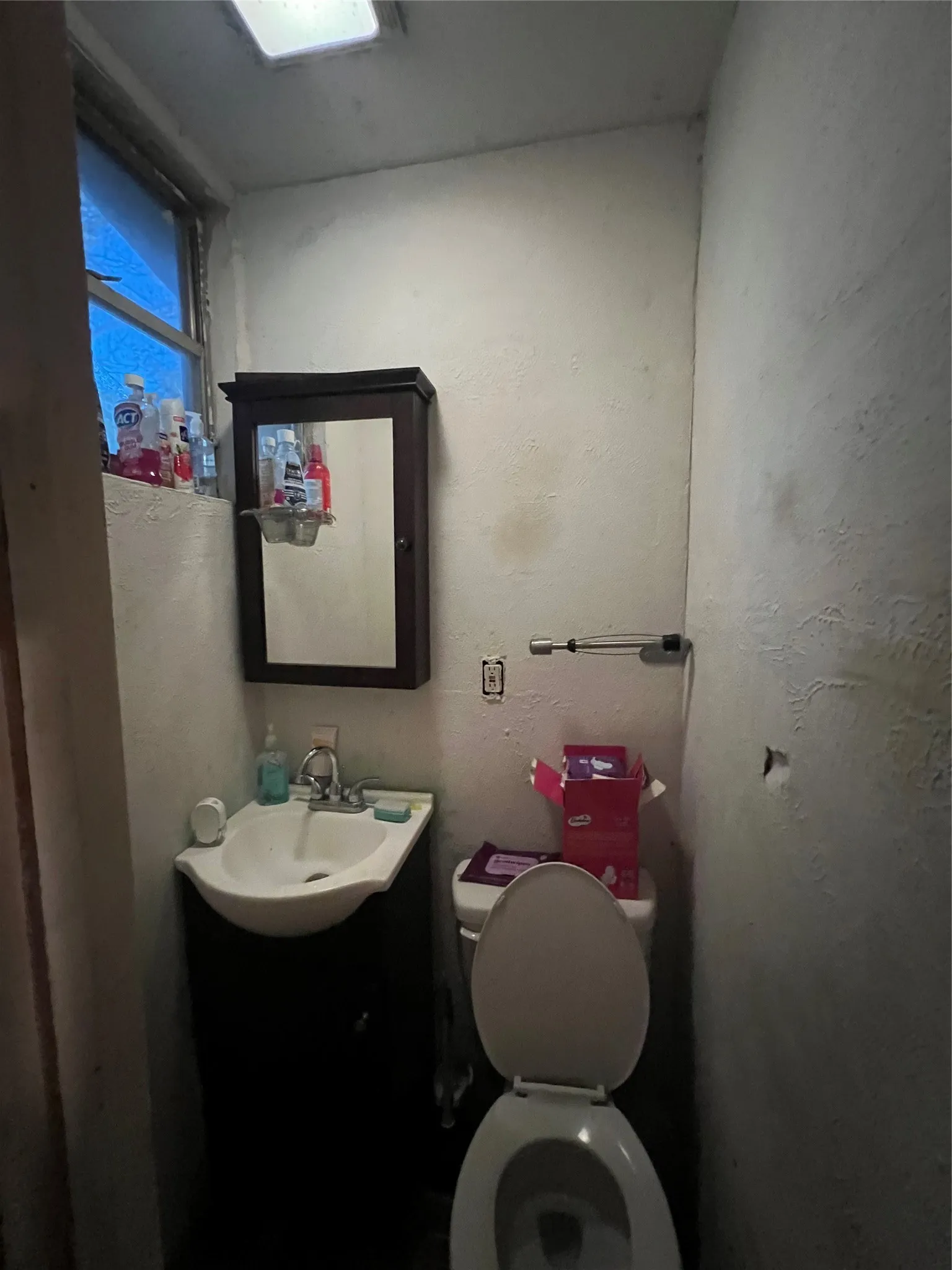 Built-in wall cabinet with mirror, wall-mounted light fixture, and window