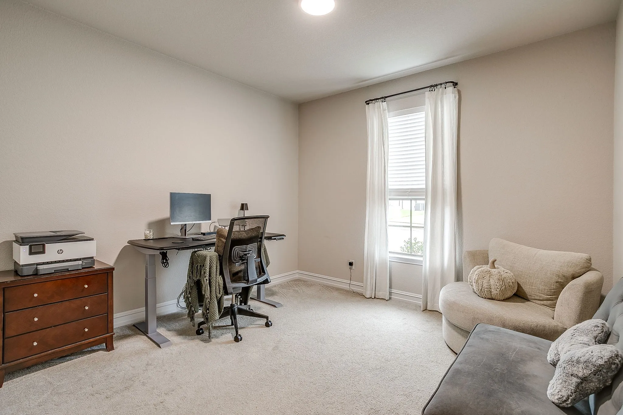Carpeted room with neutral wall tones and a window featuring blinds