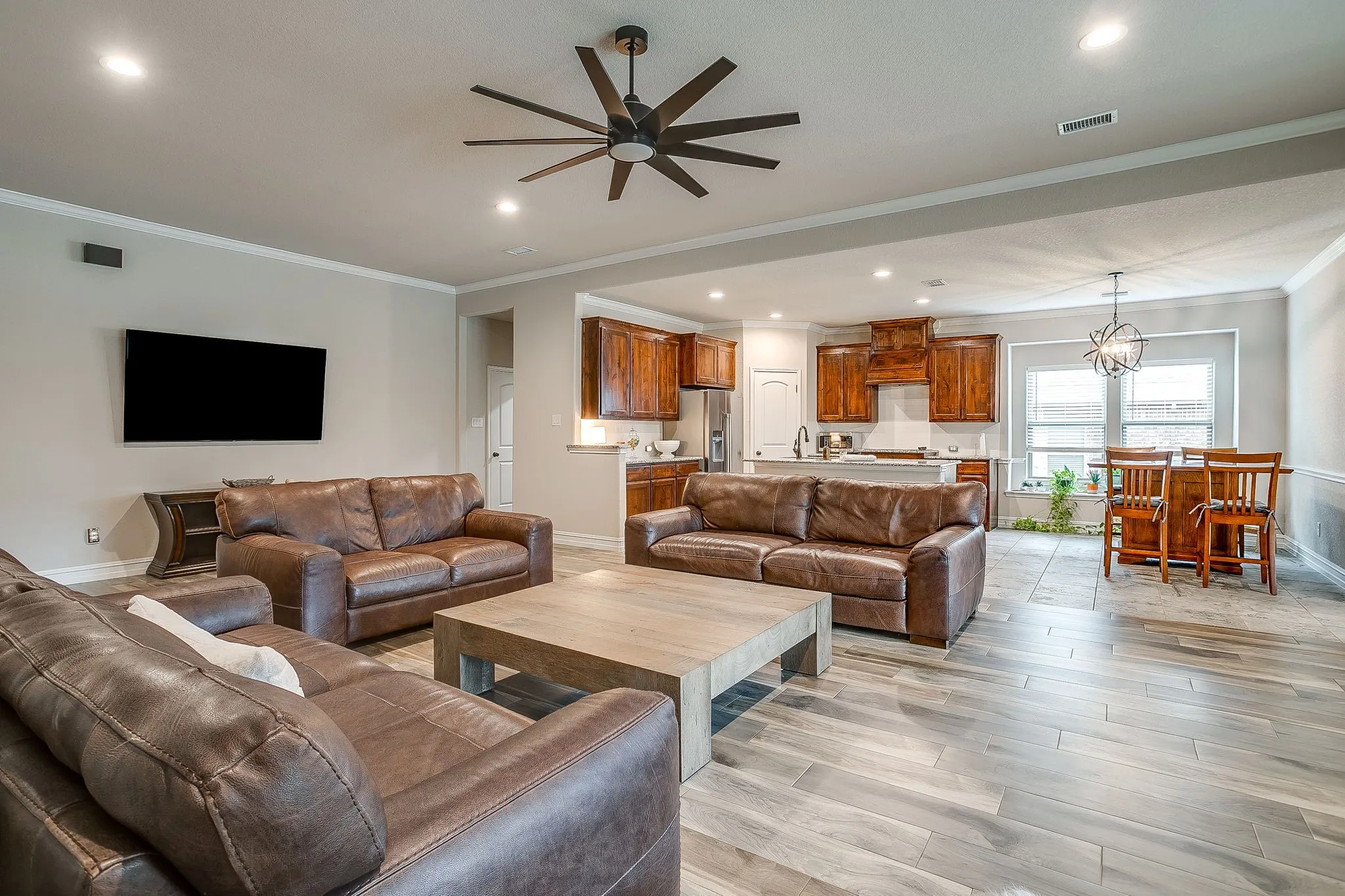 Open-concept living area featuring wood-finish flooring, recessed lighting, and a ceiling fan