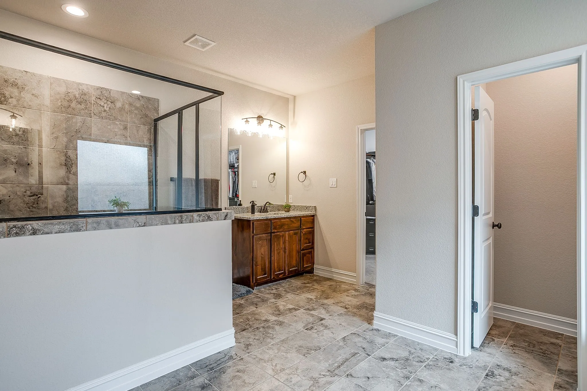 Walk-in shower with full height tiling and glass enclosure