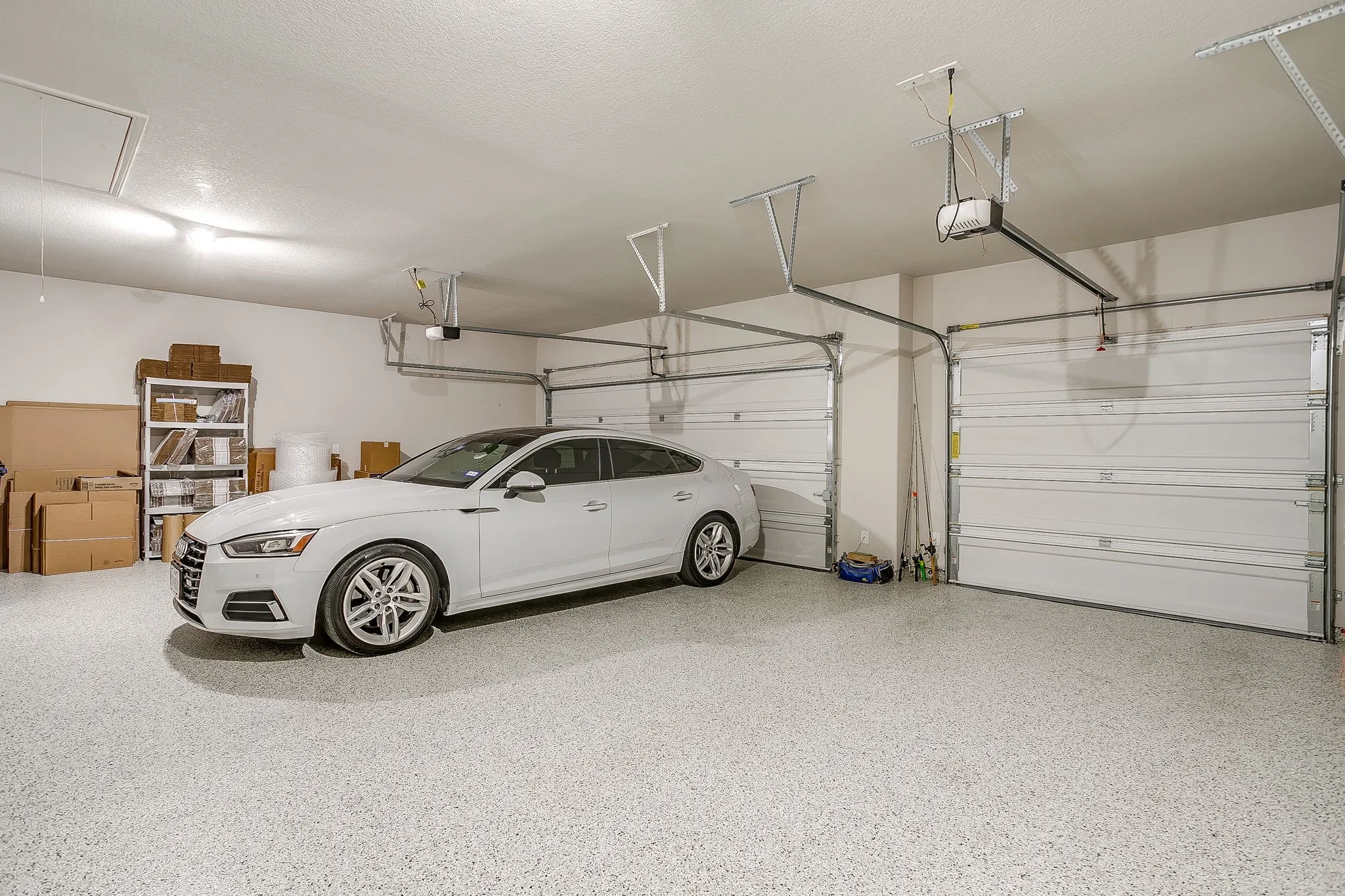 Attached two-car garage with overhead doors and an epoxy coated floor