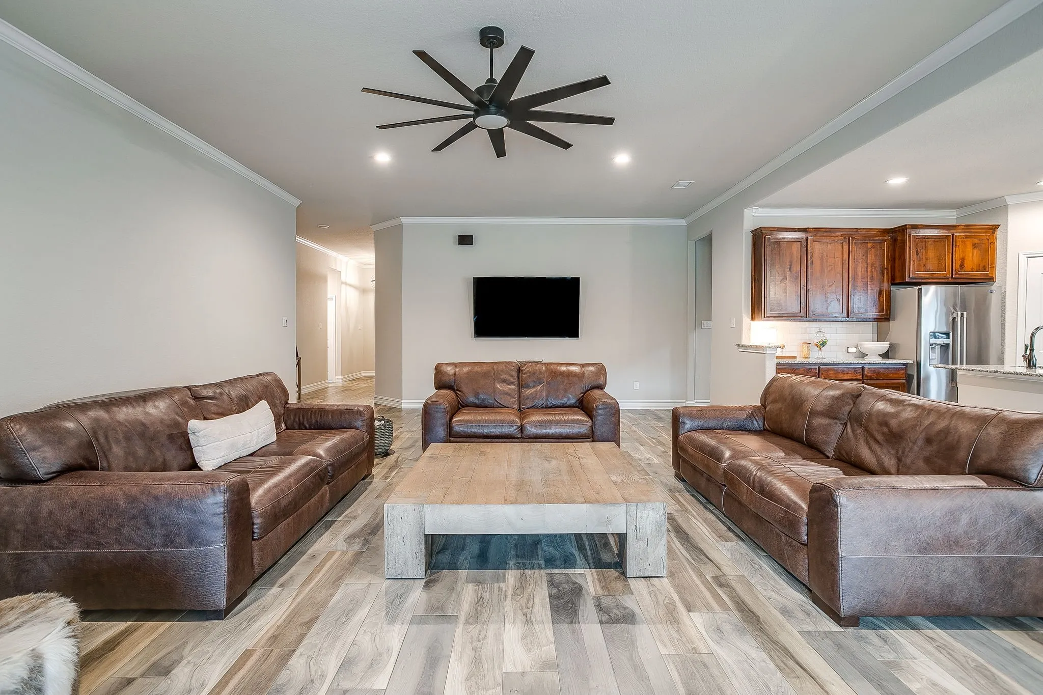 Open-concept living space featuring wood-finish flooring, recessed lighting, and a ceiling fan