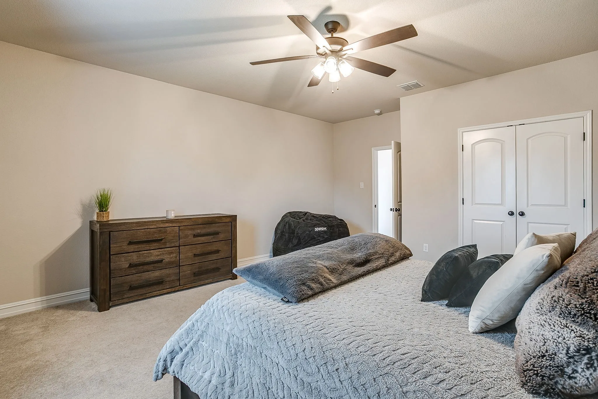 Carpeted flooring, ceiling fan with integrated lighting, and white double closet doors with arched​​‌​​​​‌​​‌‌​‌‌​​​‌‌​‌​‌​‌​​​‌​​ panels
