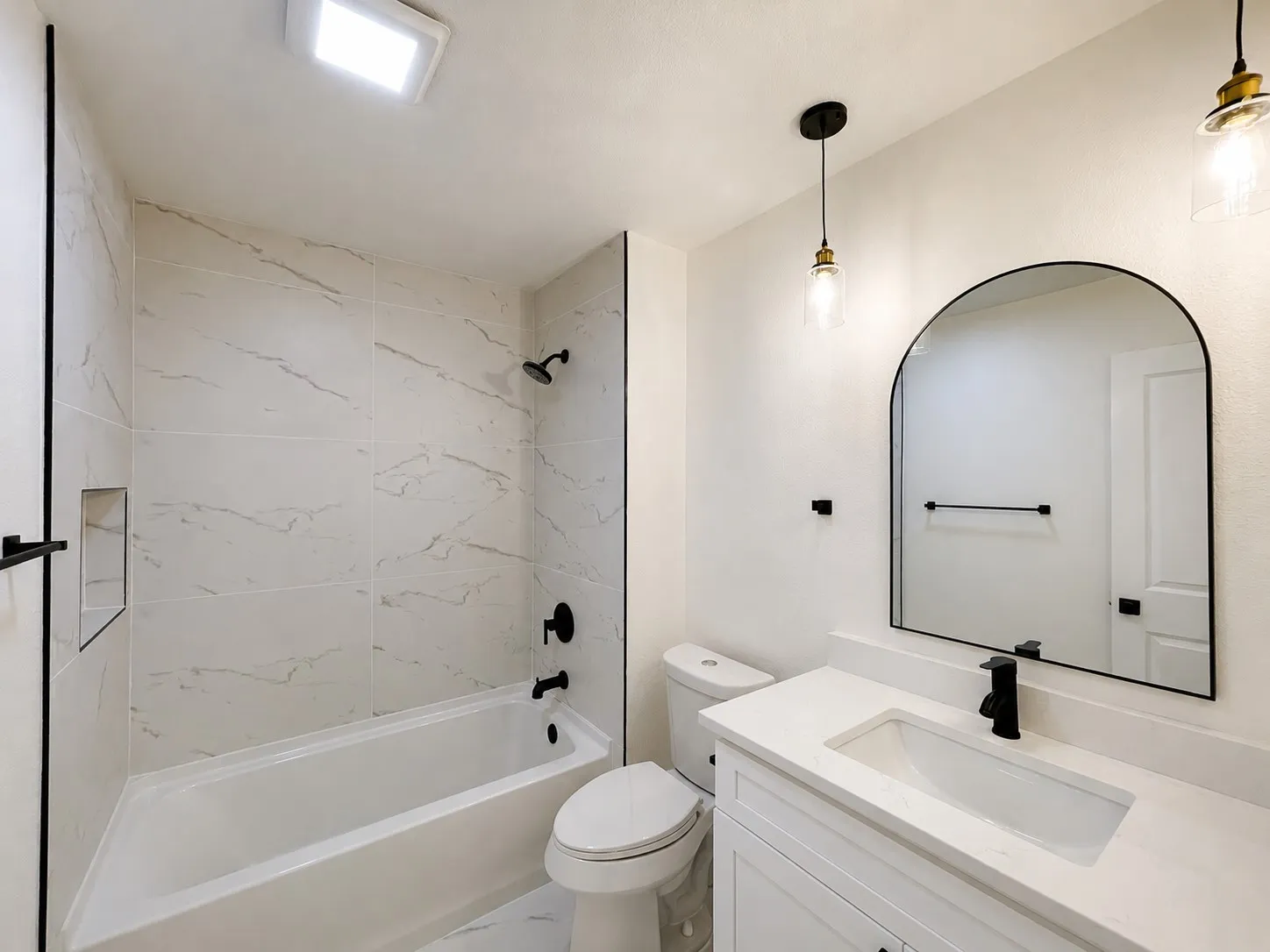 White tiled shower with a built-in niche