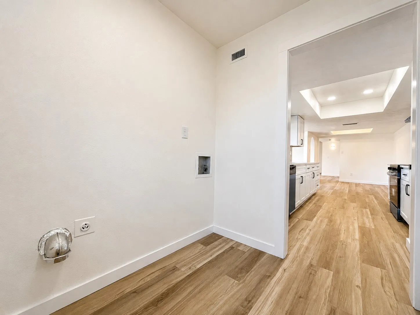 Laundry area with wood-finish flooring
