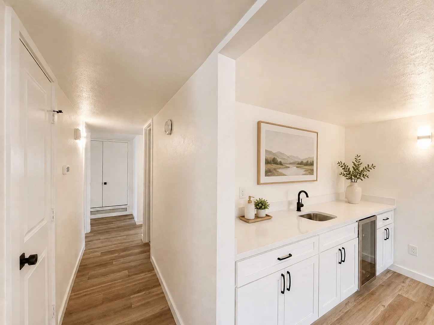 Wet bar featuring white cabinetry, quartz countertops, an undermount sink with a matte black faucet, and a beverage refrigerator