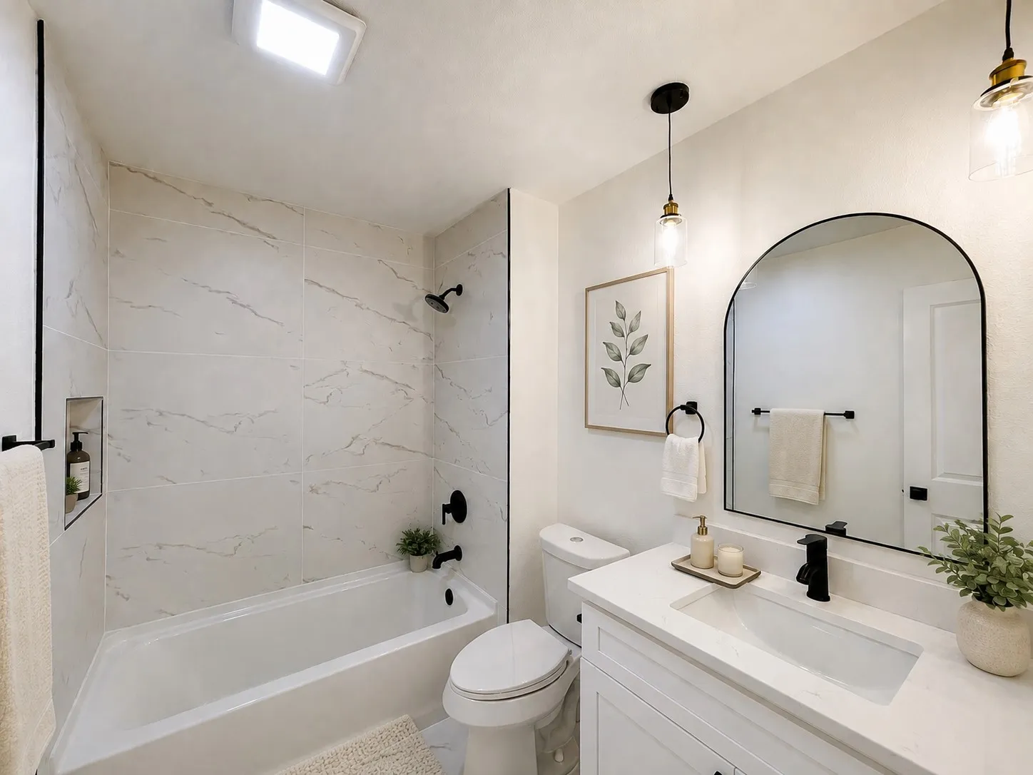 Integrated bathtub with marble-look wall tiling and a built-in shower niche