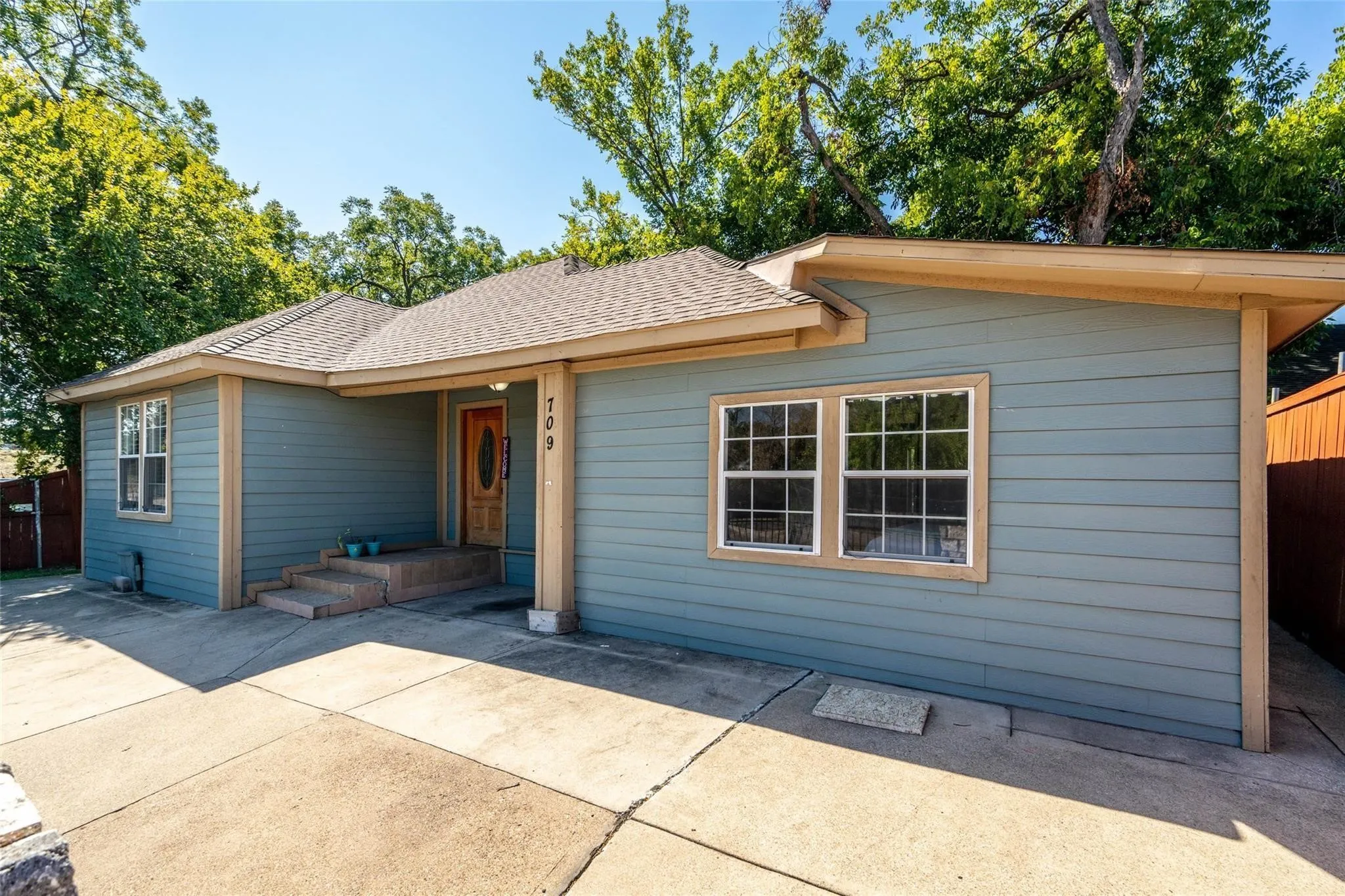 Exterior featuring horizontal siding, a composite shingle roof, and a wood-paneled entry door