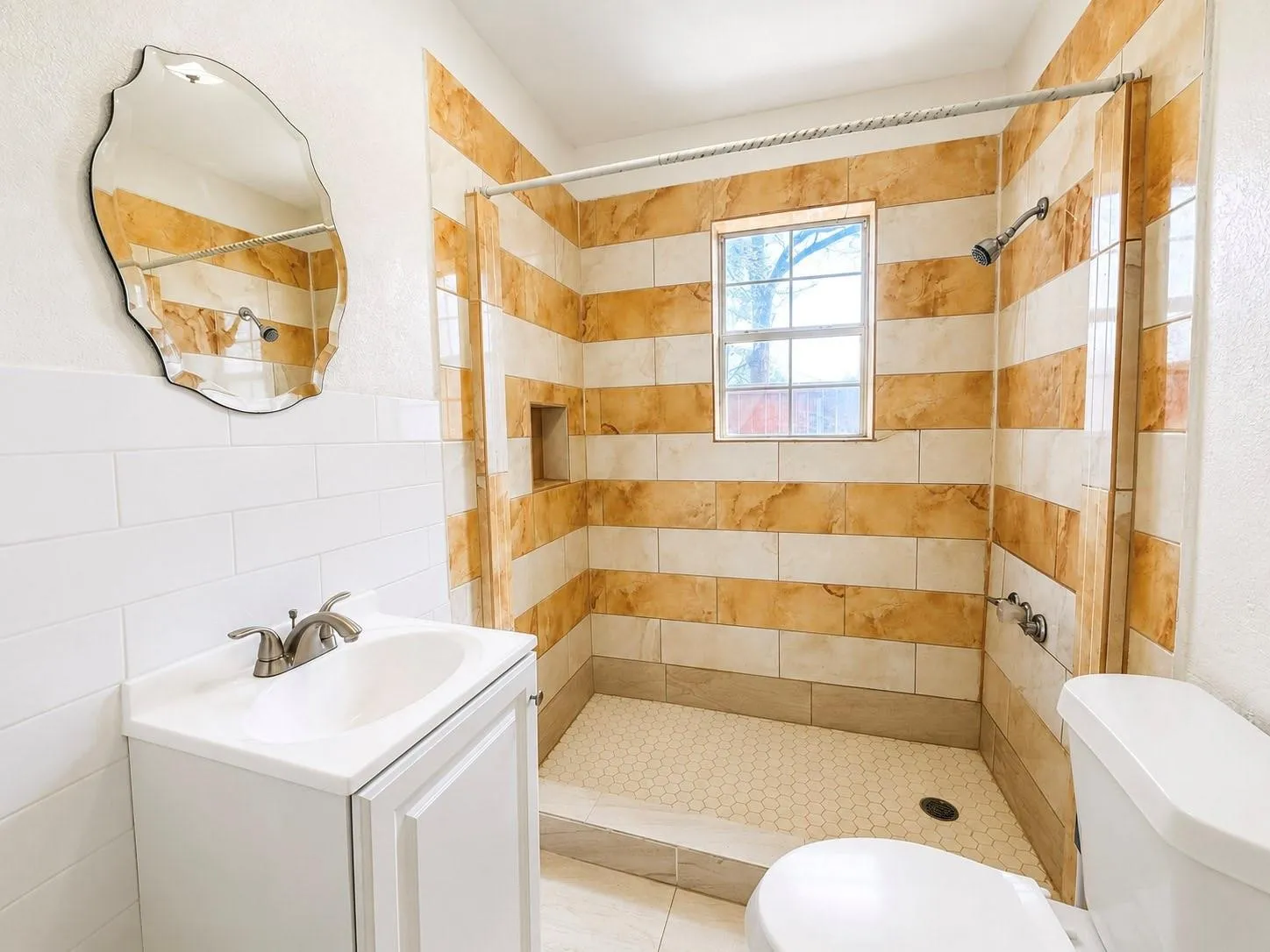Walk-in shower with horizontal striped tiling and recessed niche
