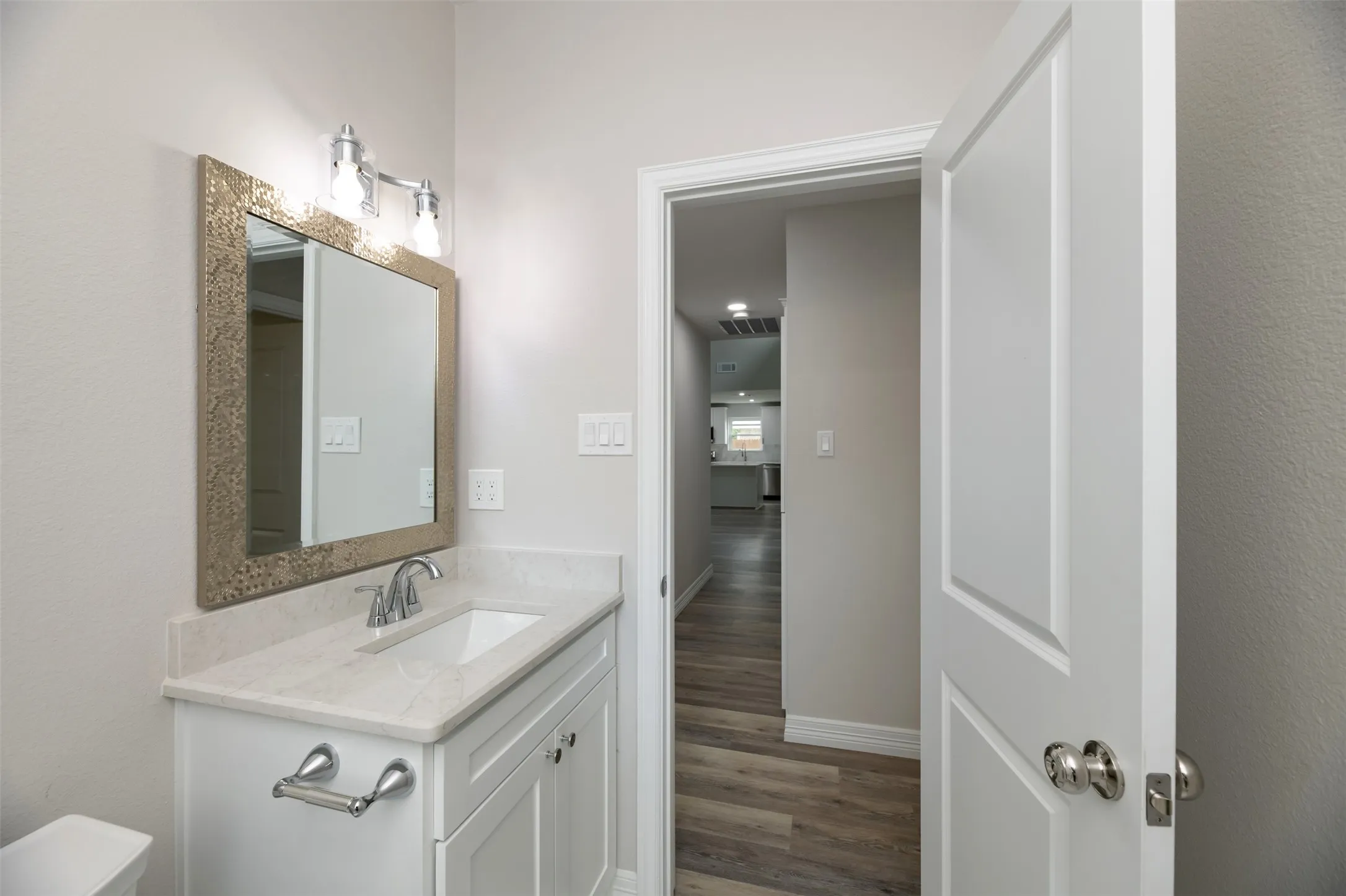 White vanity with a light-colored countertop and integrated sink