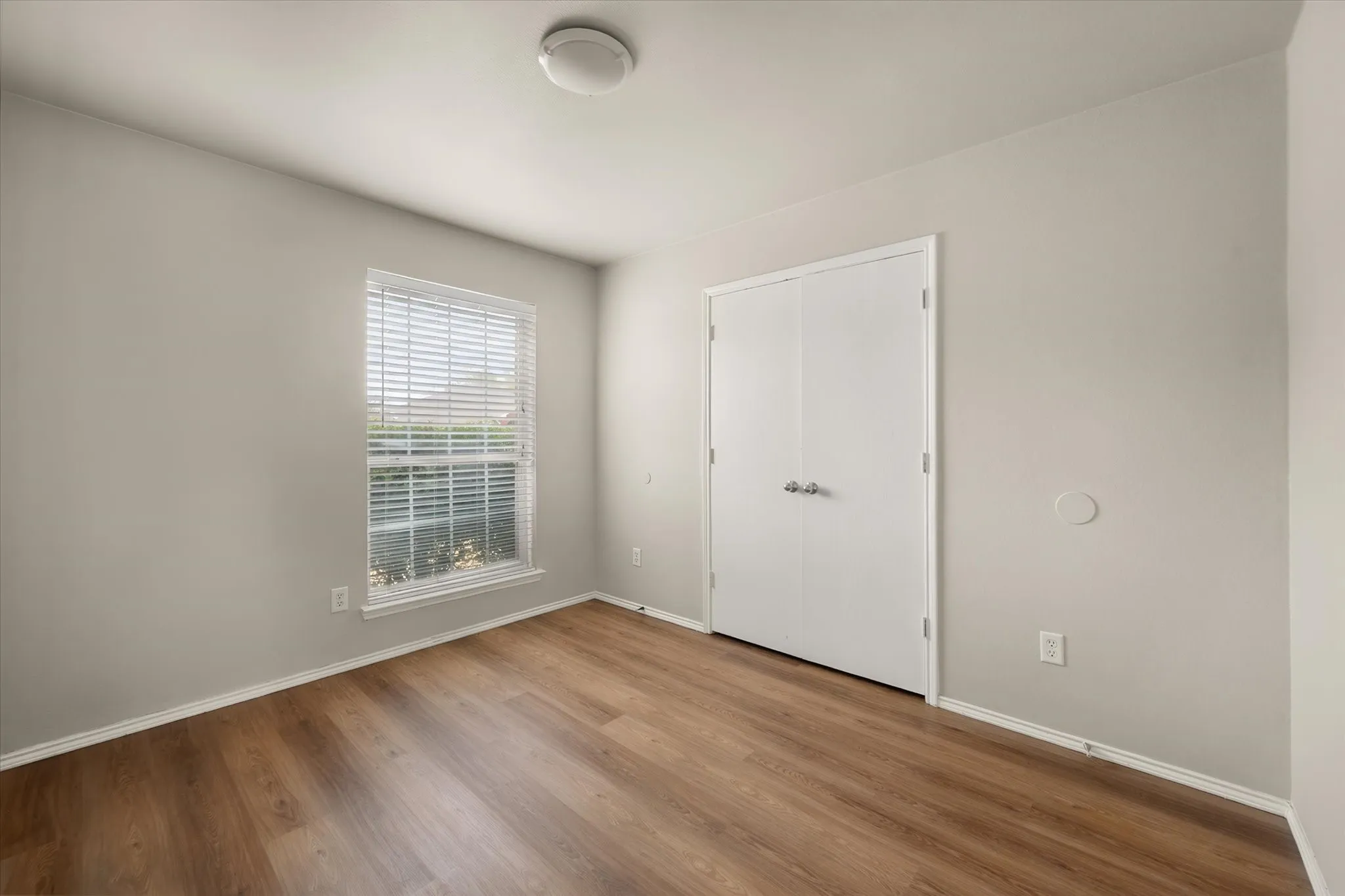 Secondary bedroom with wood look laminate flooring
