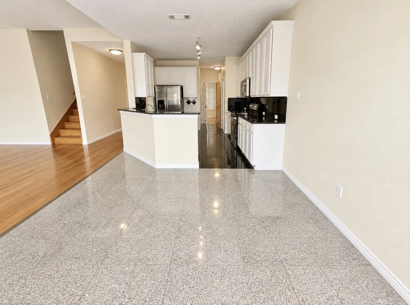 Kitchen featuring white cabinetry, stainless steel appliances, and dark countertops