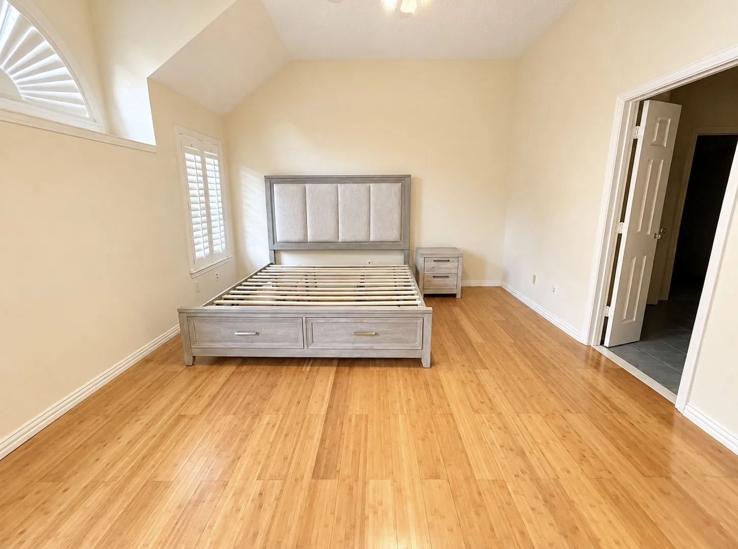 Wood-finish flooring, plantation shutters, and an arched transom window