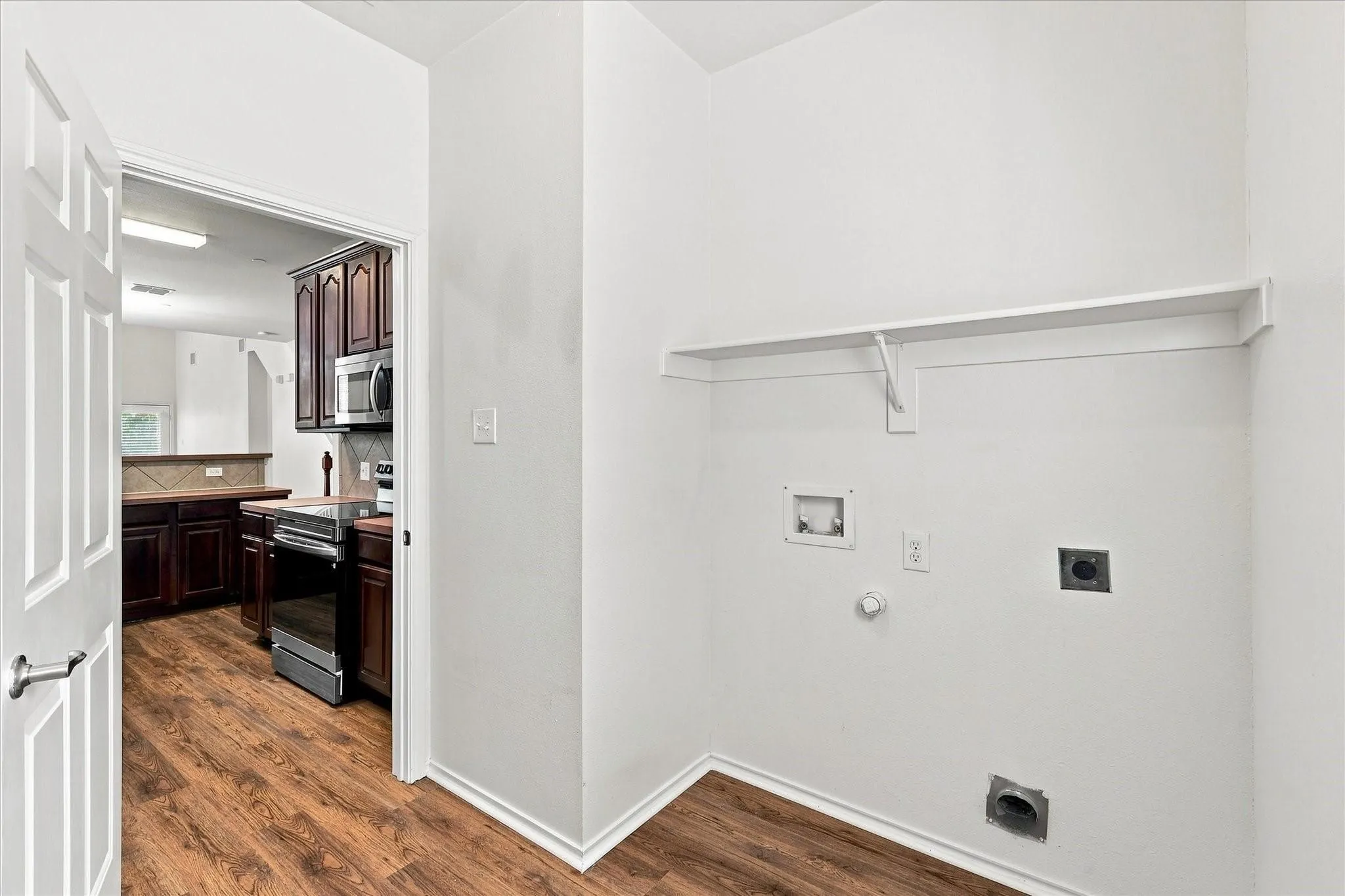 Wood-finish flooring throughout, with a built-in shelf and appliance hookups