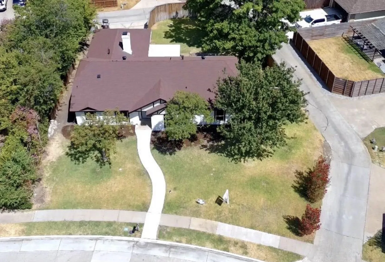 Traditional exterior with a brown shingle roof, white siding, and dark trim accents