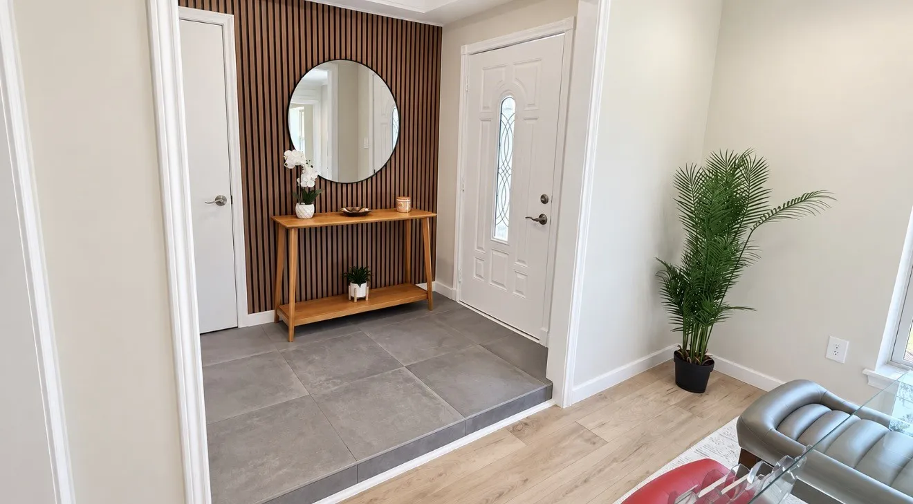 Entryway featuring a decorative accent wall with vertical wood paneling, gray large-format tile flooring, and a white entry door with frosted glass detailing