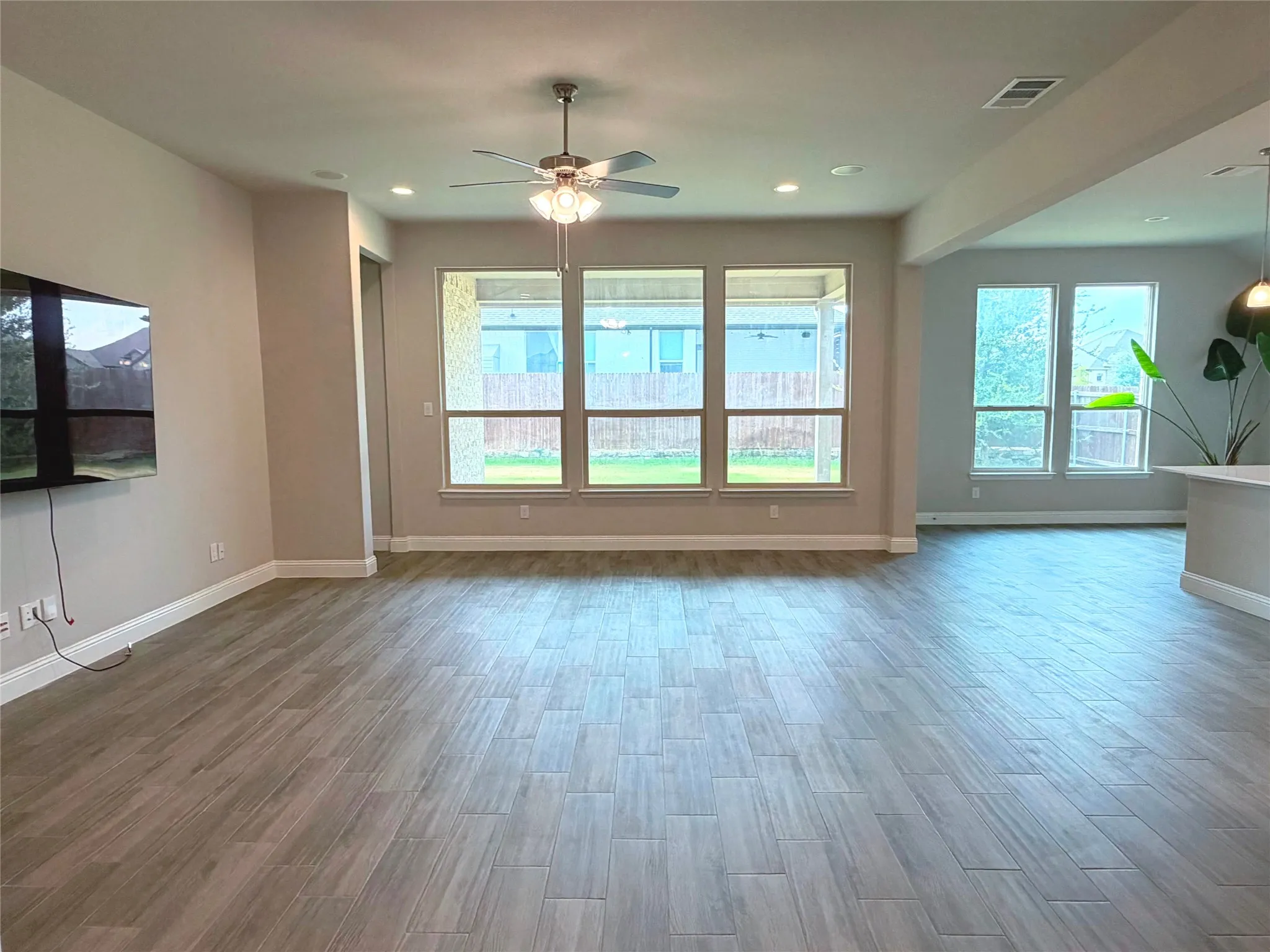 Spacious room with wood-finish flooring, recessed lighting, and a ceiling fan