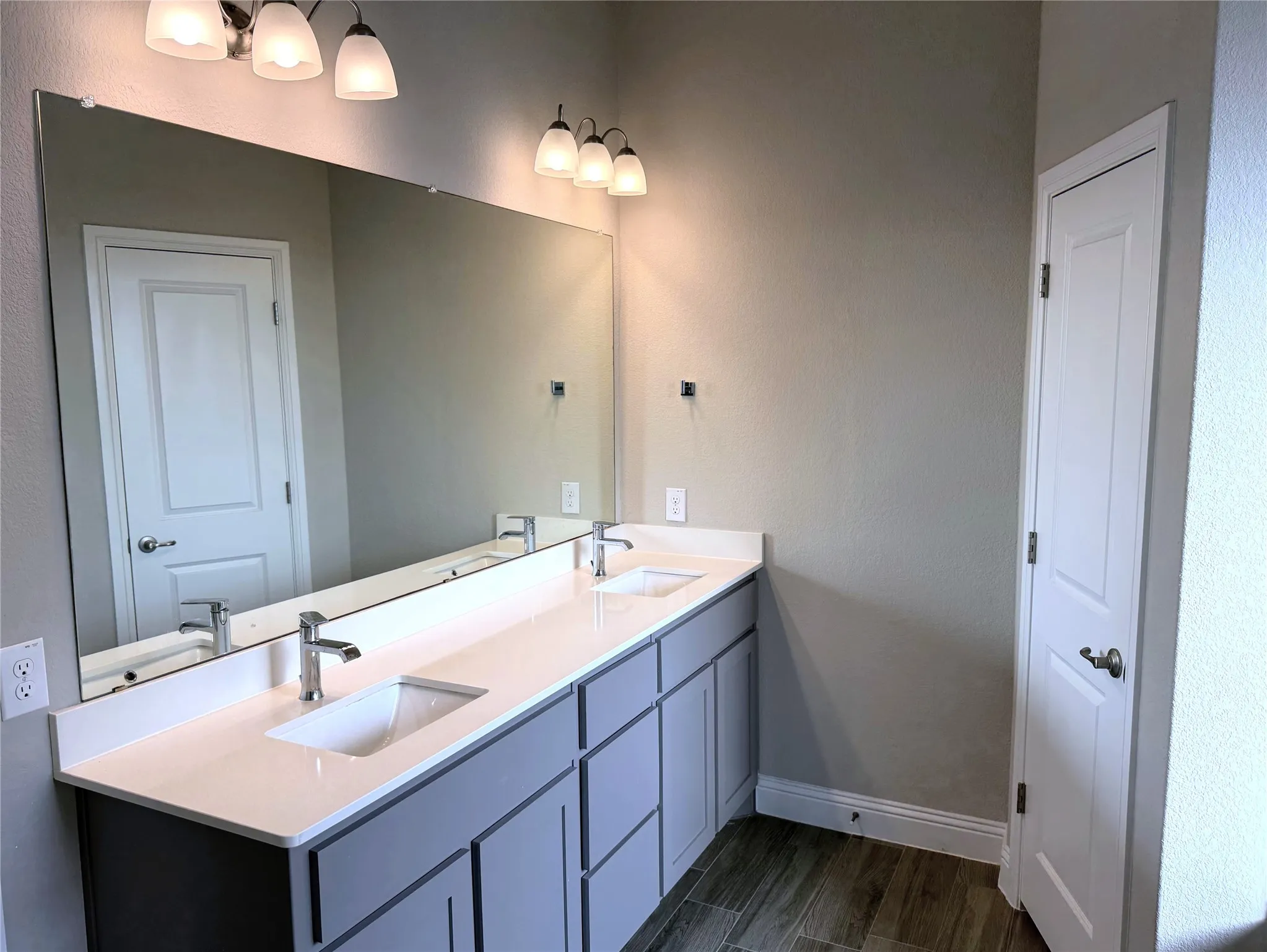 Dual vanity with undermount sinks, chrome fixtures, and a white countertop