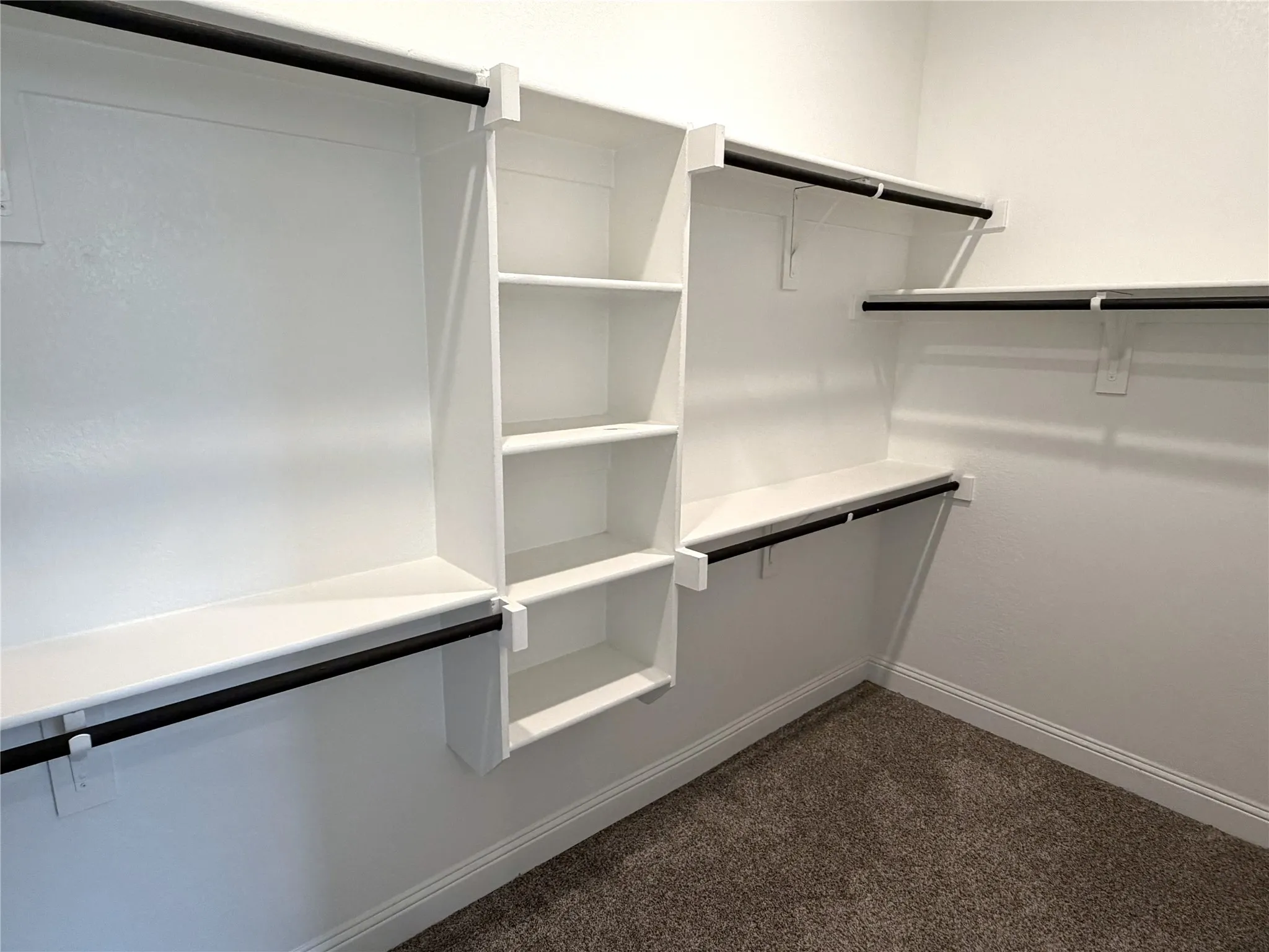 Built-in shelving, multiple hanging rods, and an integrated storage tower