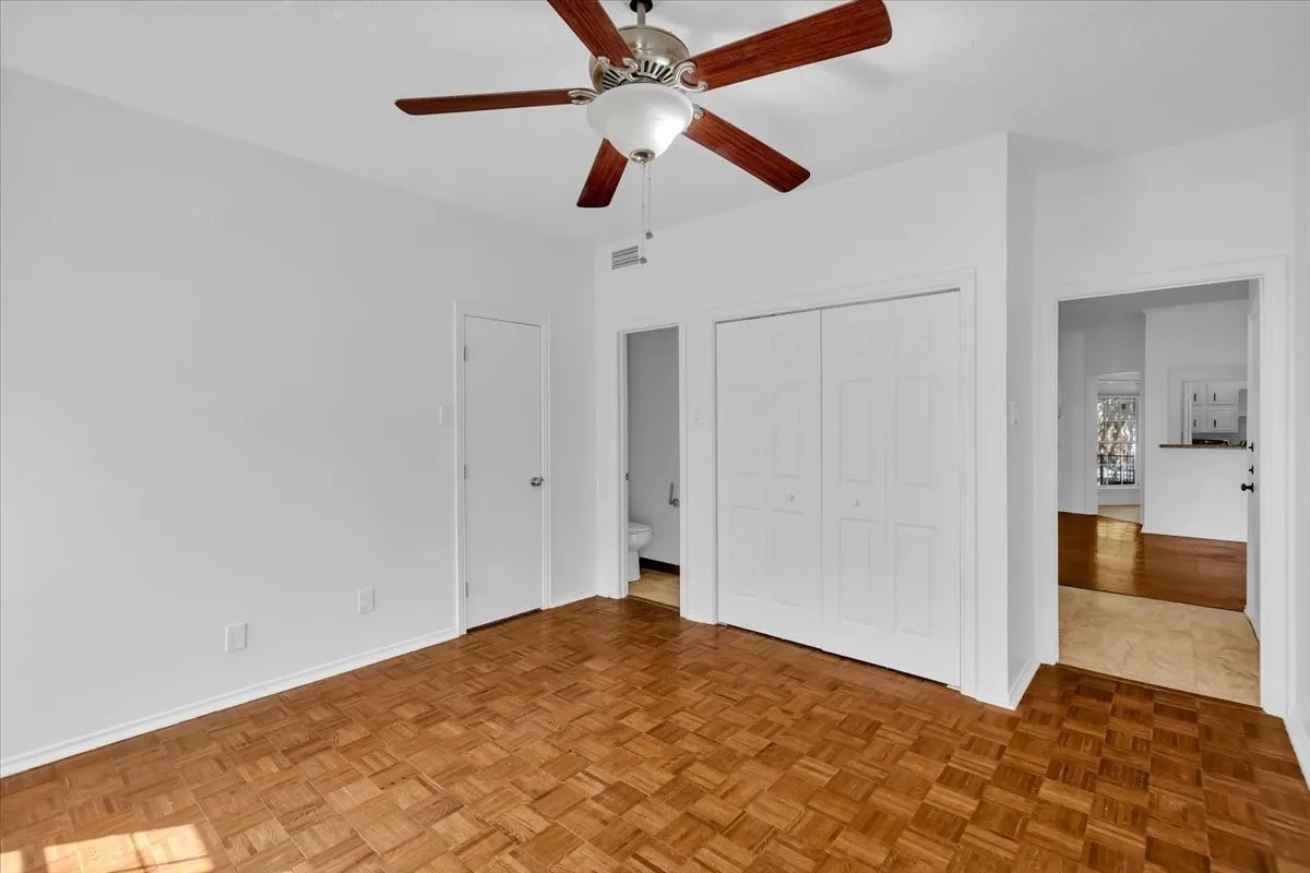 Primary bedroom with view of hallway, primary bath and two walk in closets