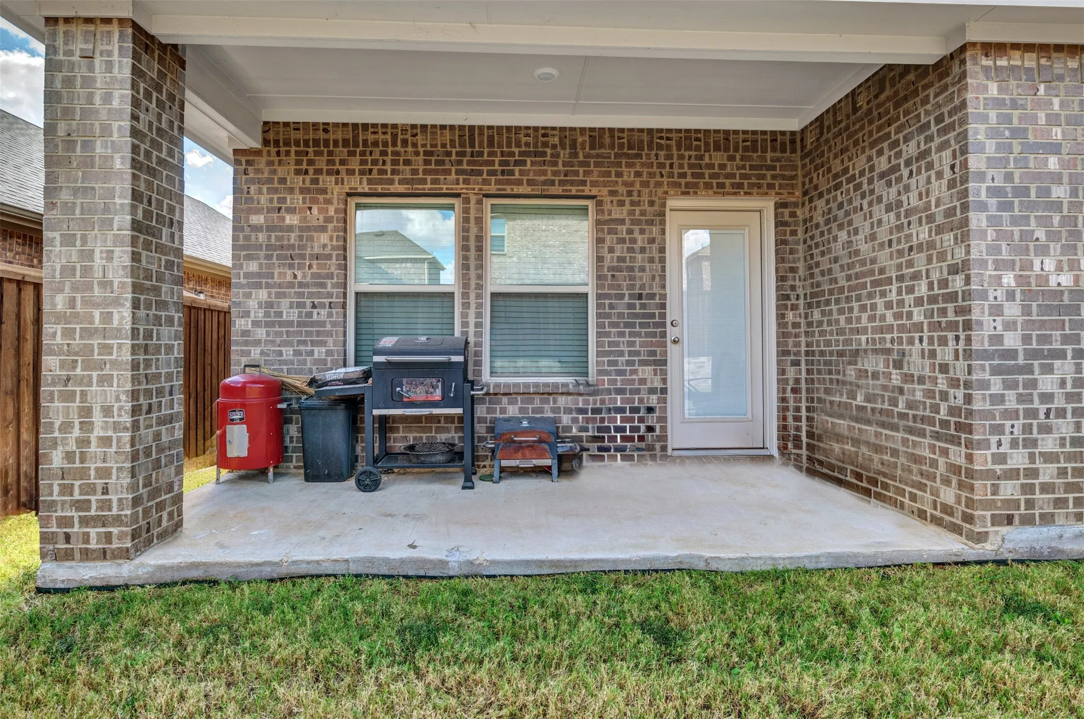 Doorway to property featuring a lawn and a patio