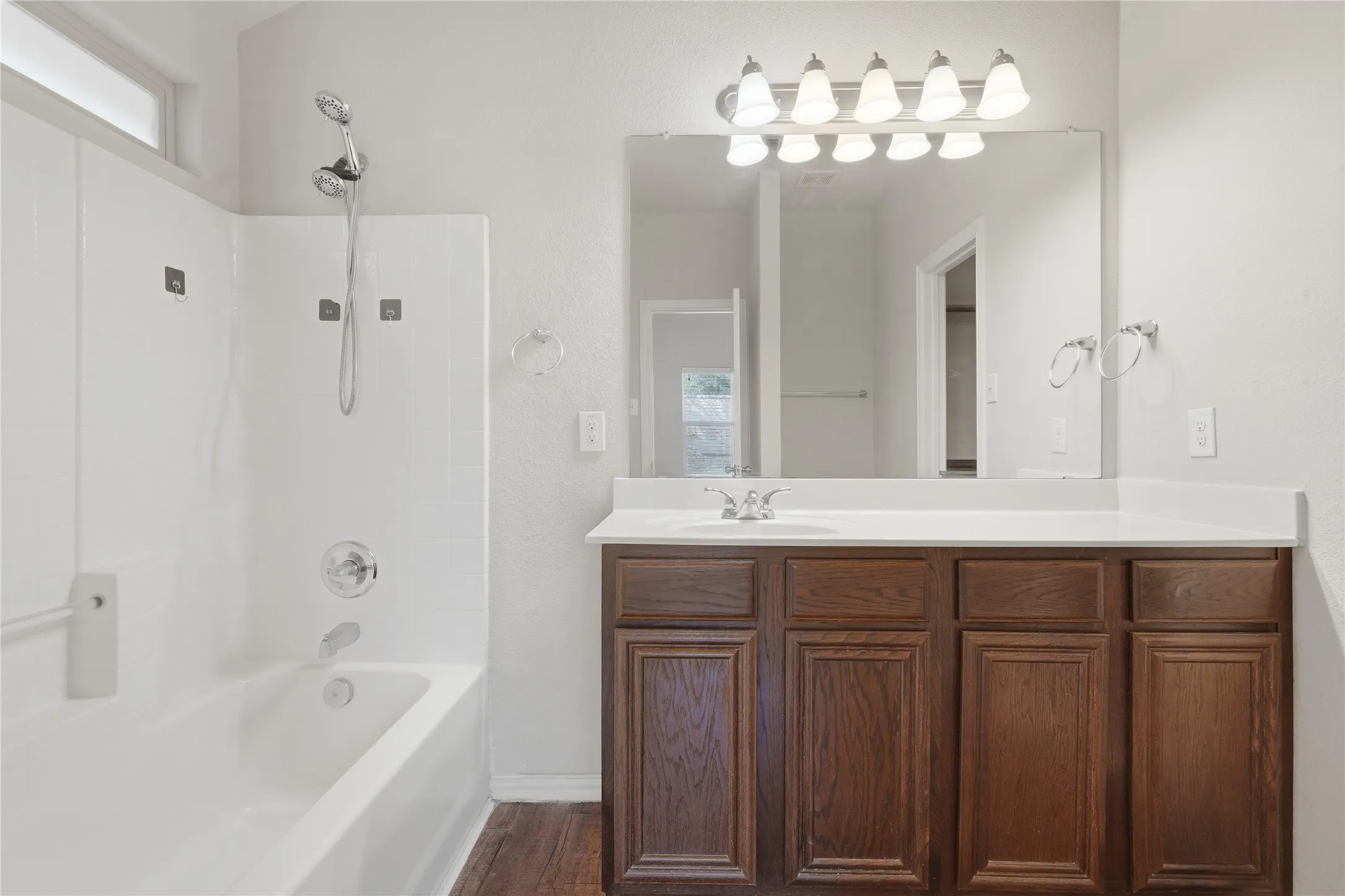 White bathtub and shower combination with a transom window