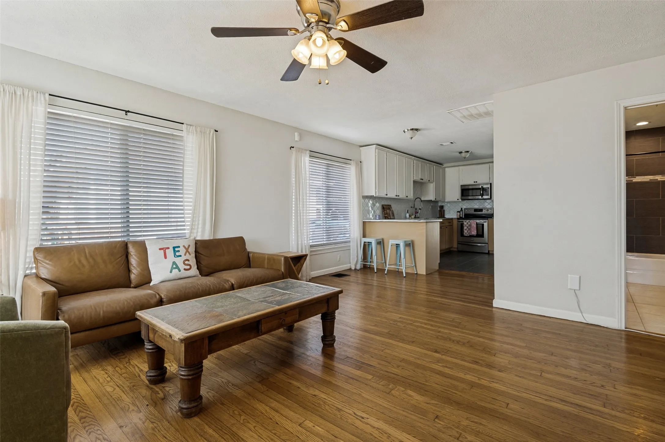 Wood-finish flooring throughout, with a ceiling fan and recessed lighting