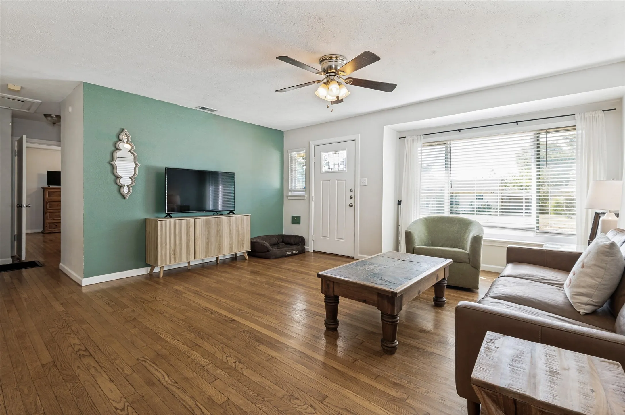 Hardwood flooring throughout, with a decorative accent wall