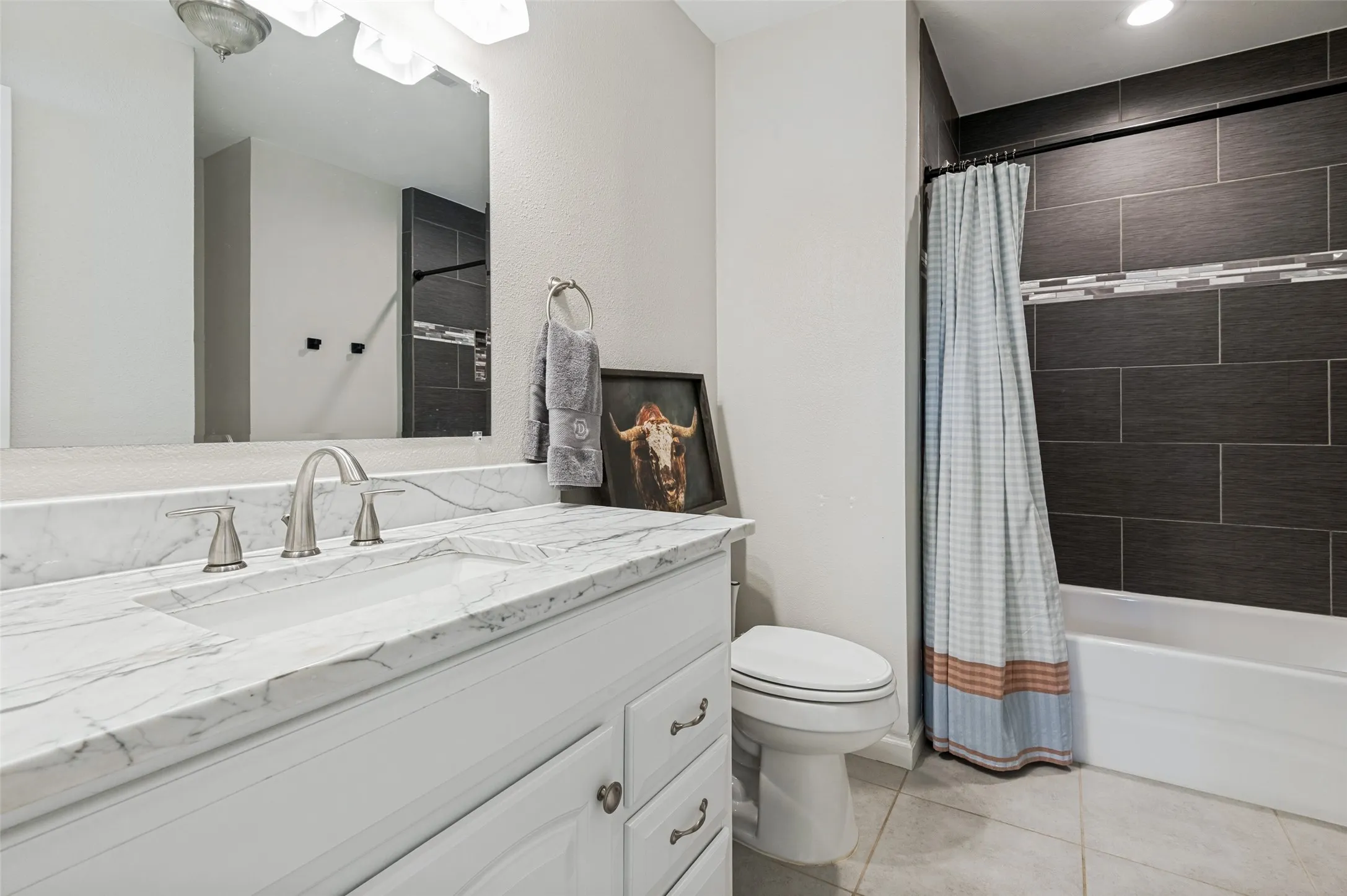 White vanity with an integrated rectangular sink, brushed nickel faucet, and a large wall-mounted mirror