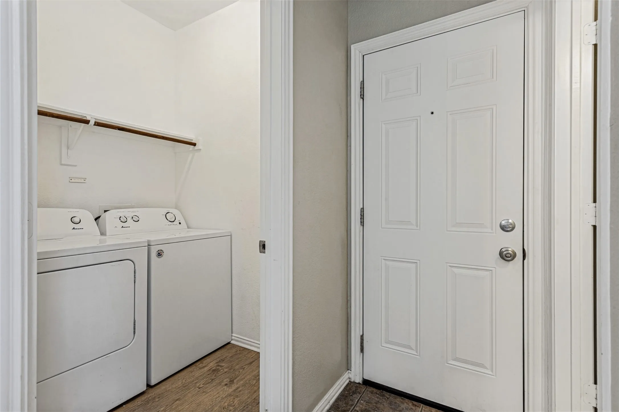 Laundry area with wood-finish flooring and additional shelving