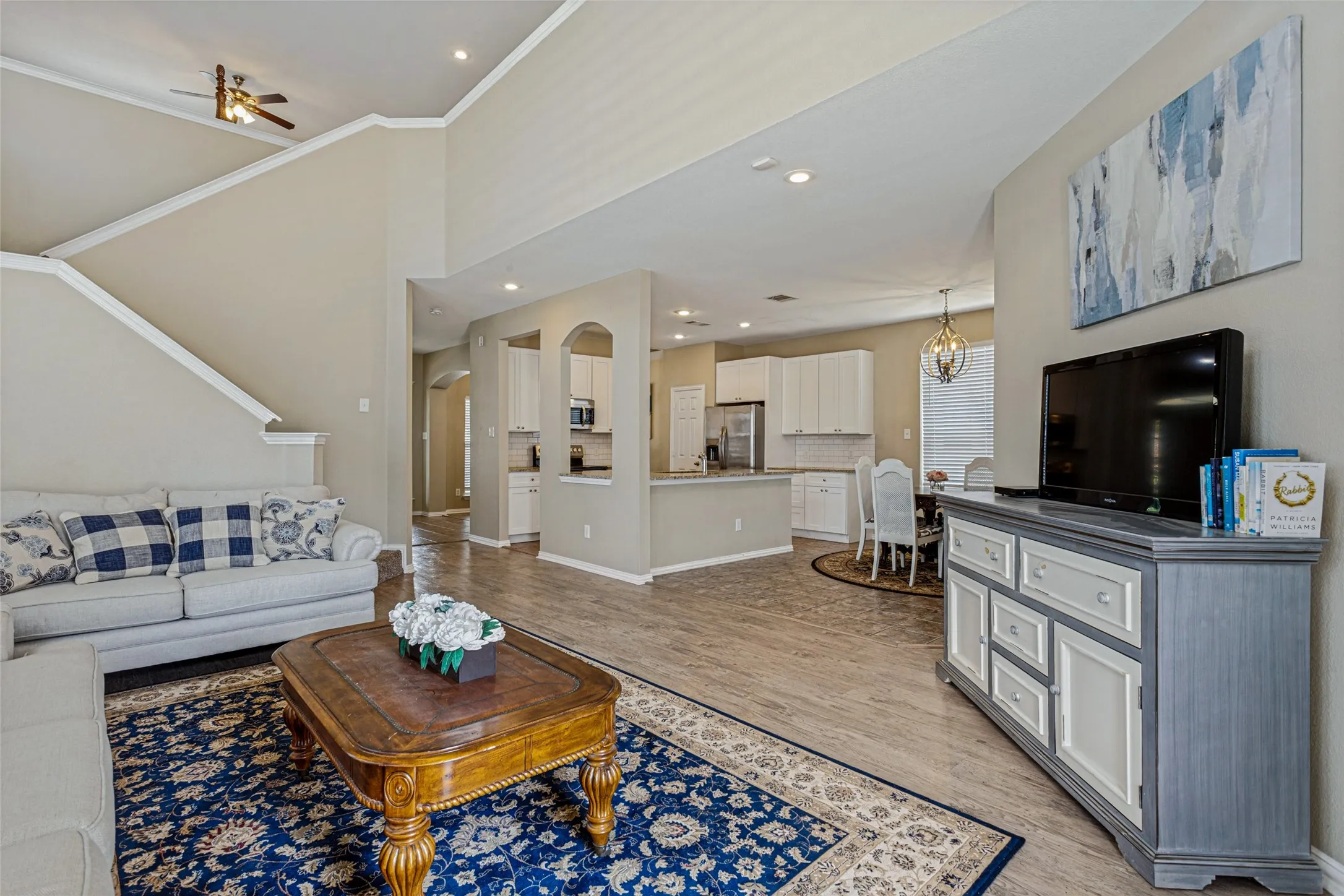 Vaulted ceiling, recessed lighting, wood-finish flooring, staircase, and an open-concept layout