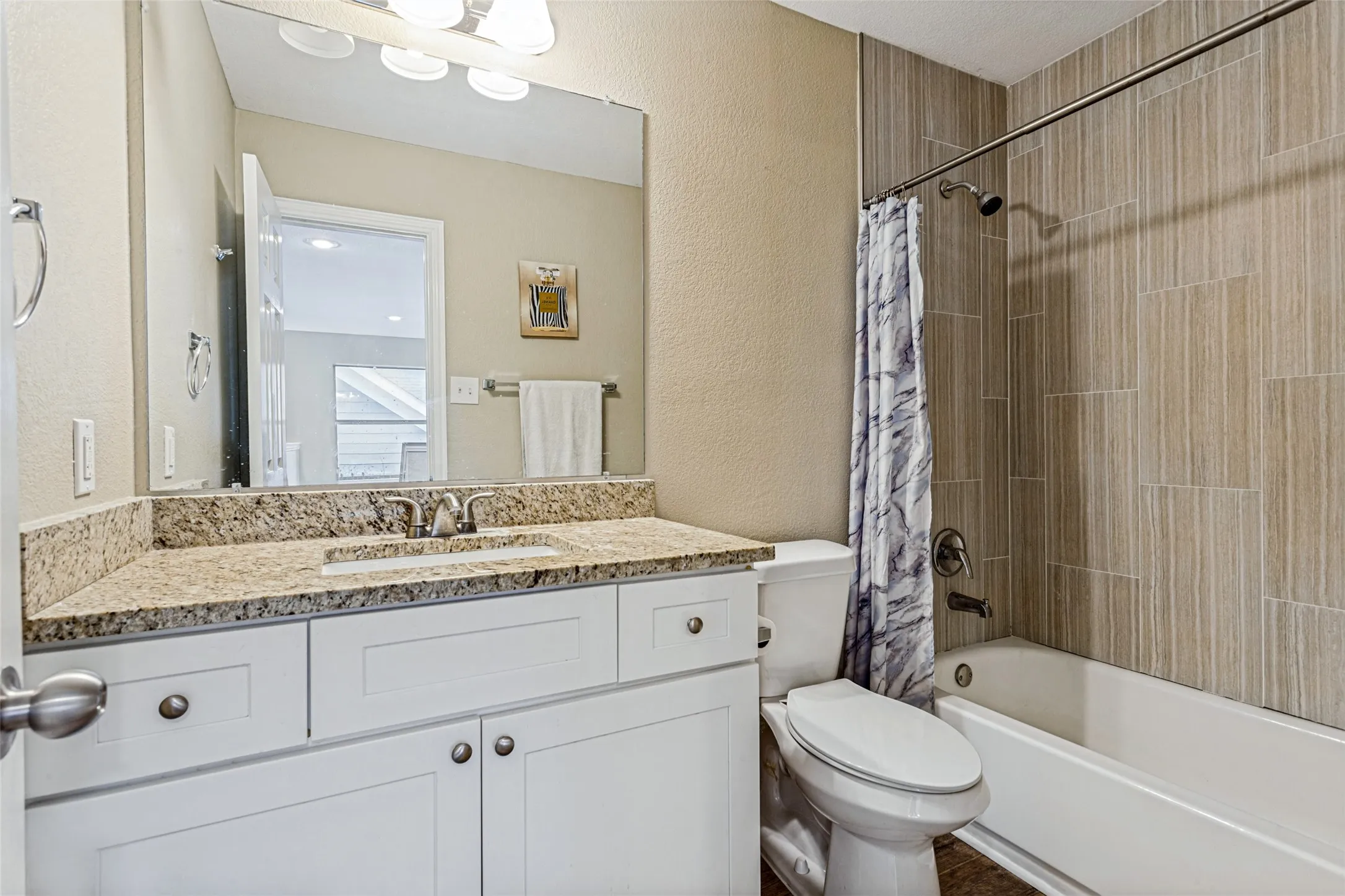 White vanity with granite countertop, integrated sink, and chrome faucet