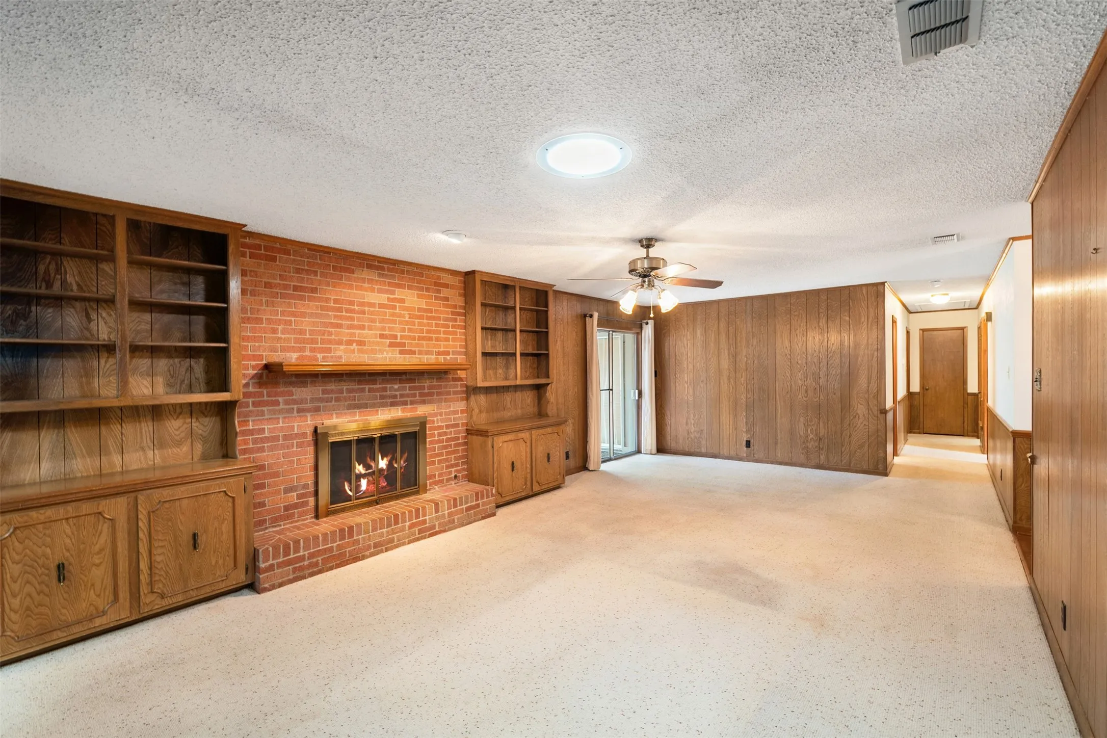 Living room with wood burning fireplace and built in cabinets