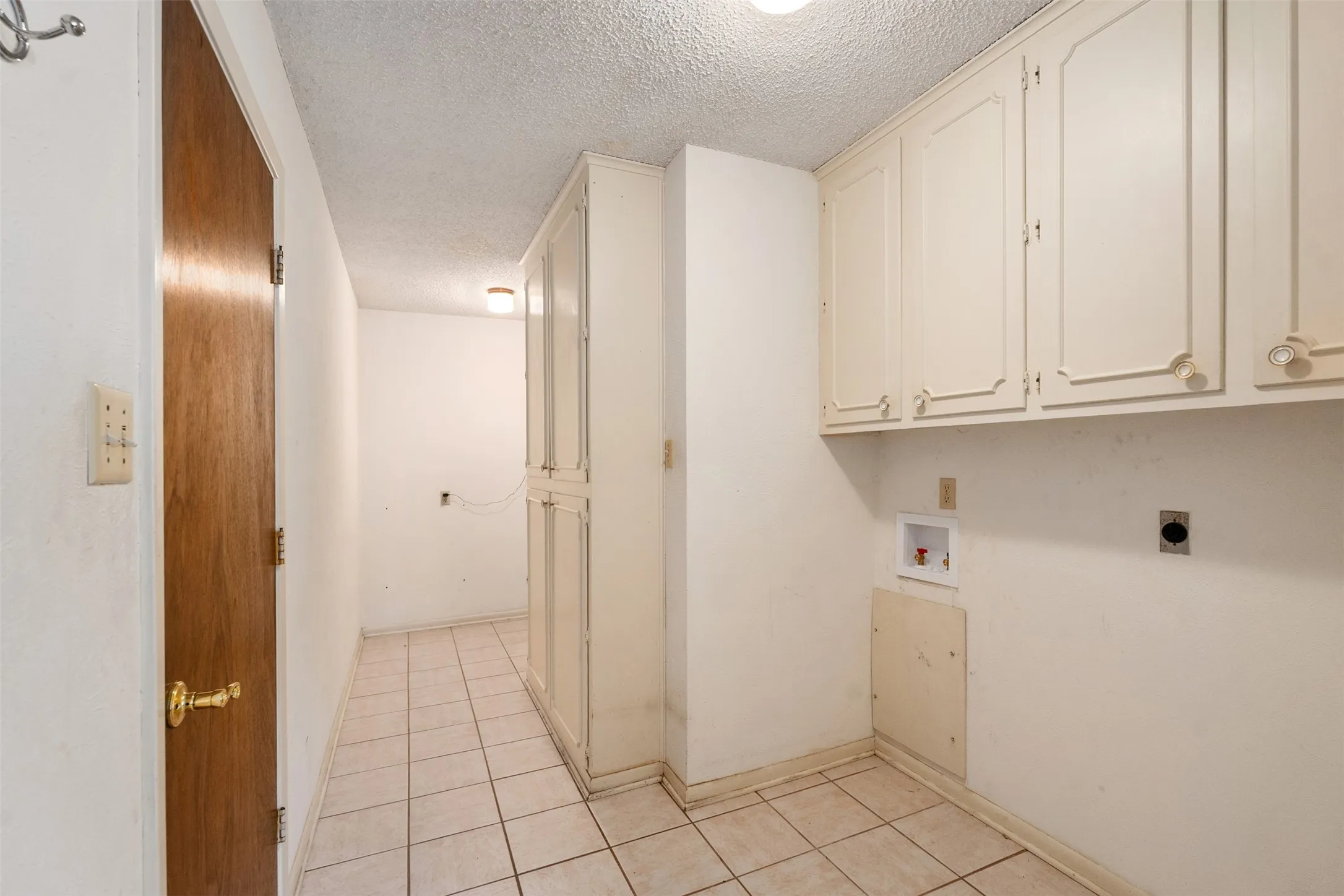 Laundry room off of garage with lots of storage
