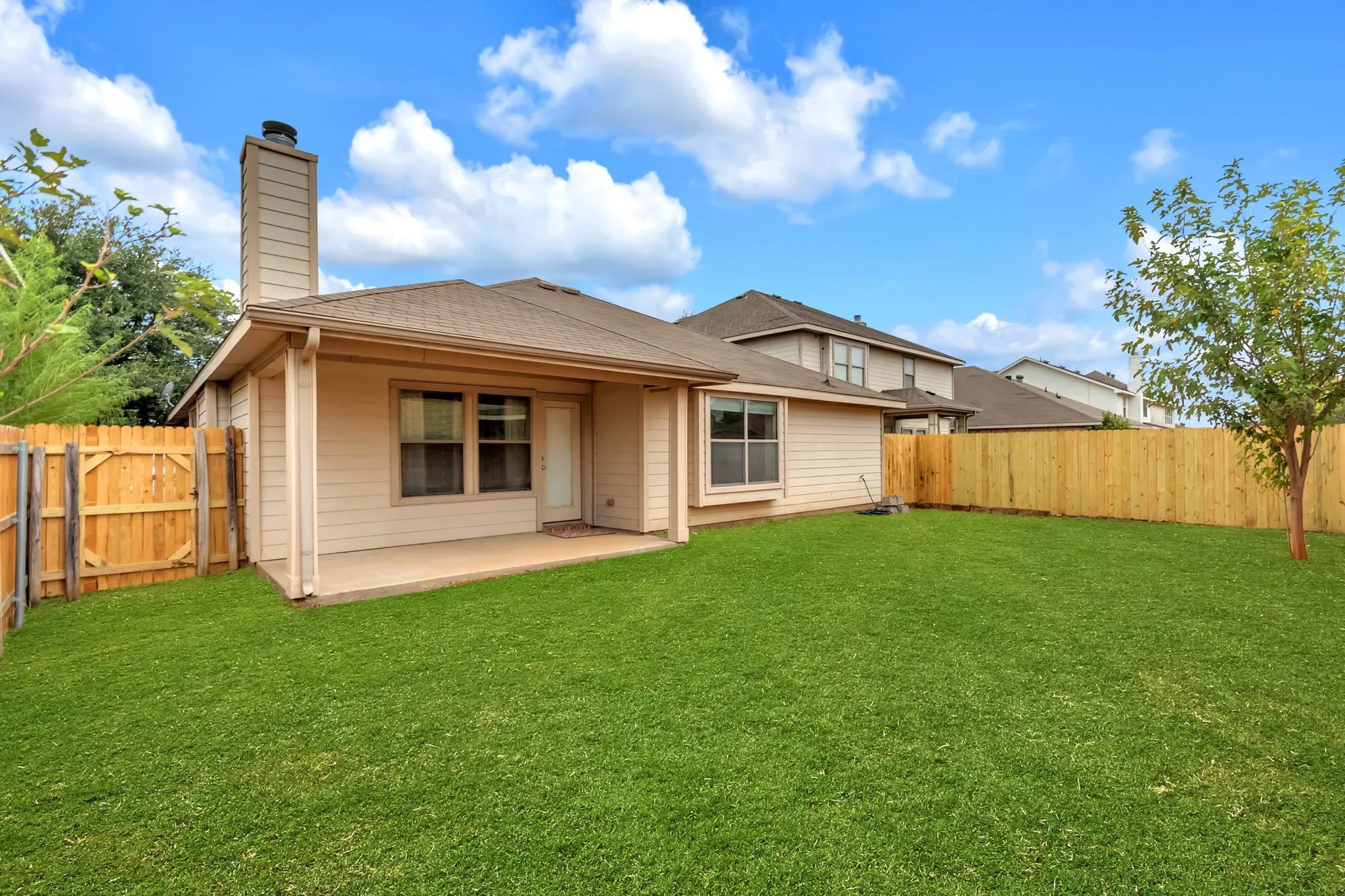 Expansive grass backyard with wood privacy fencing