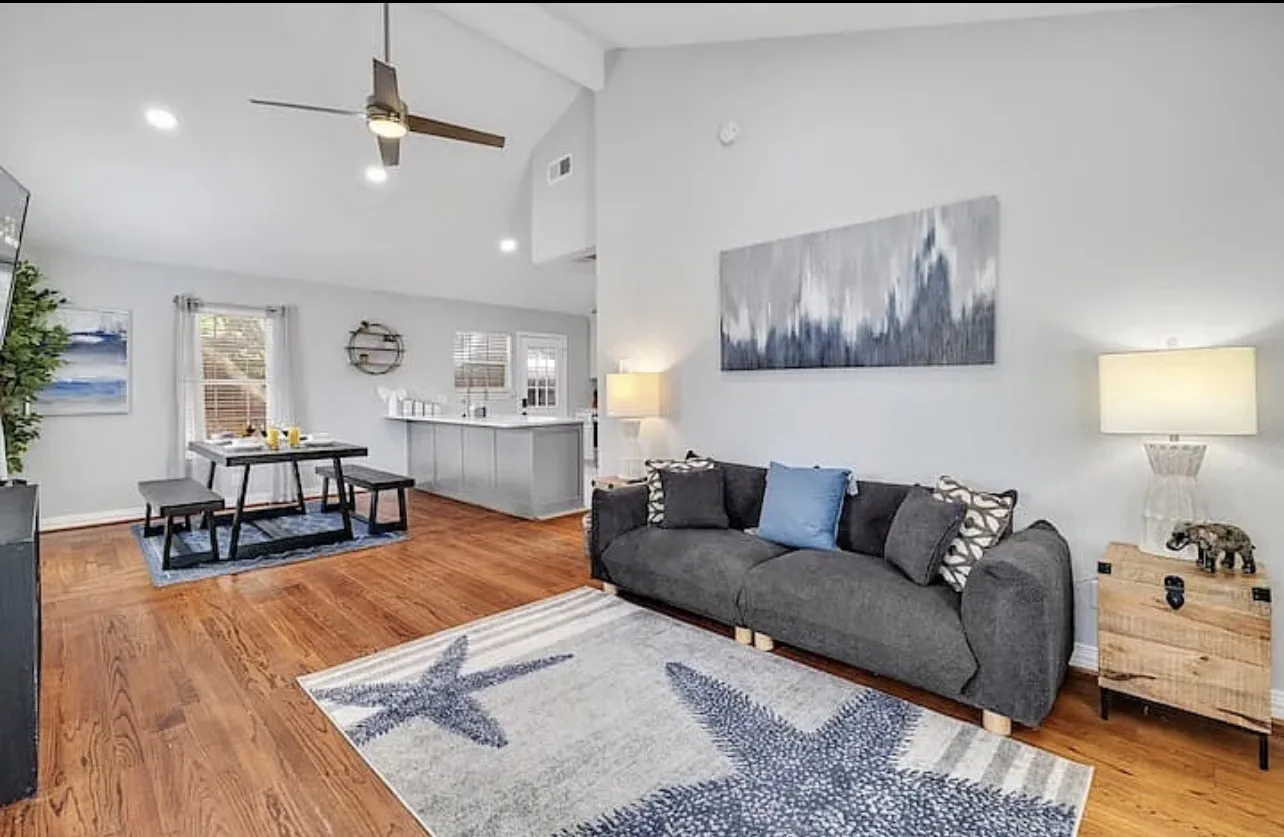 Hardwood flooring throughout, vaulted ceiling, recessed lighting, and a kitchen island with a white countertop