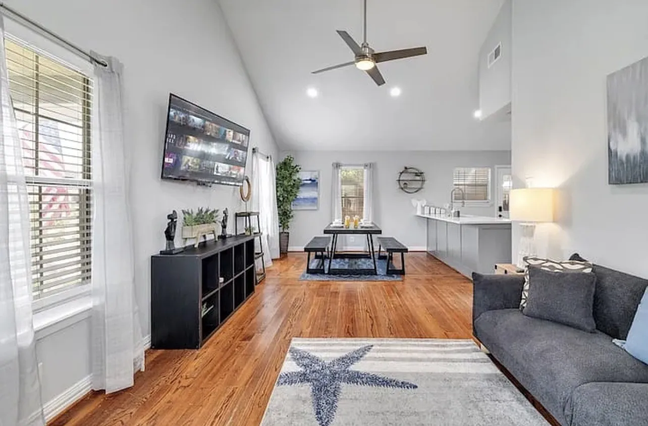 Vaulted ceilings with a ceiling fan, recessed lighting, wood-finish flooring, and a kitchen island with seating