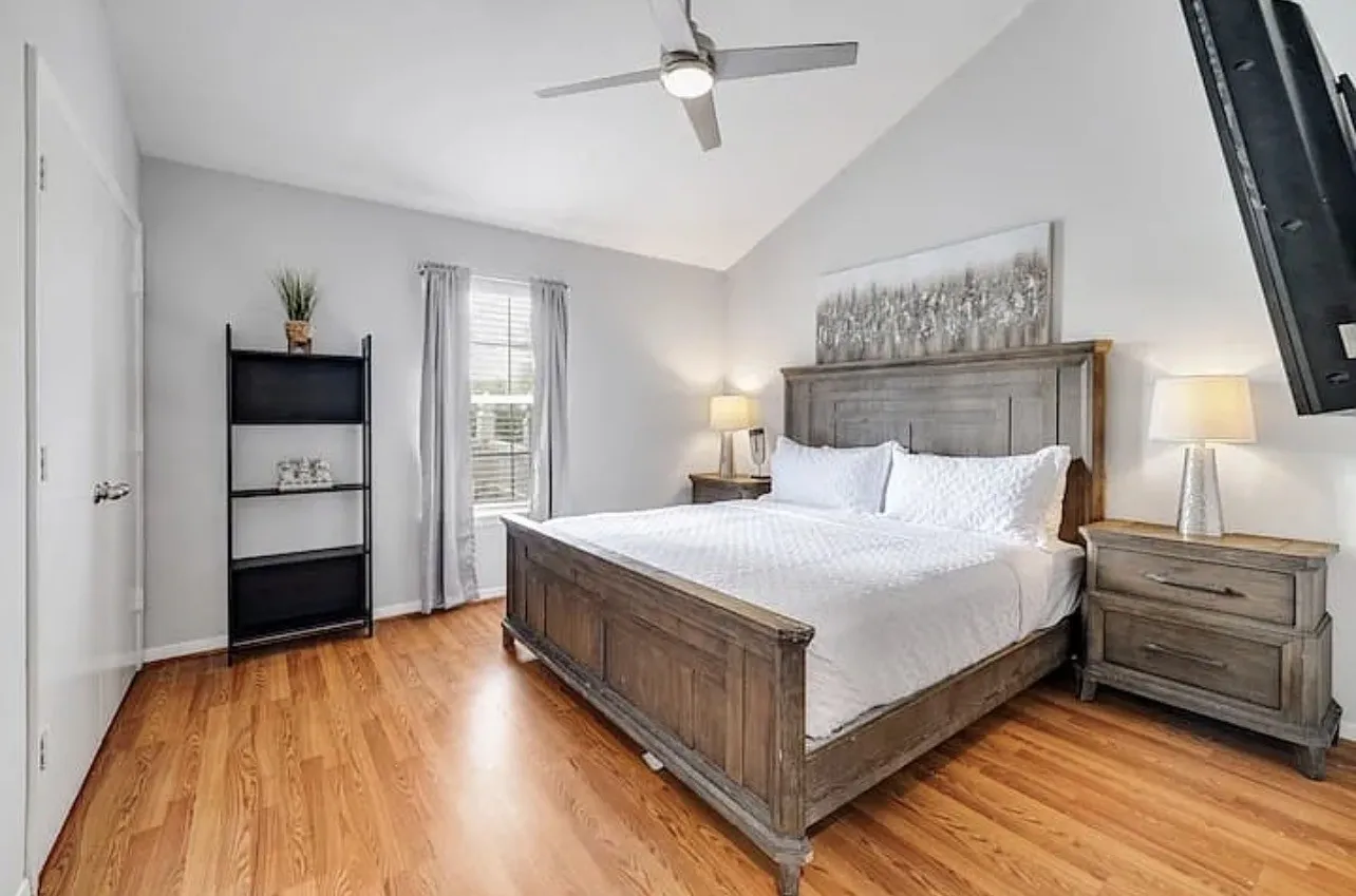 Vaulted ceiling, wood-finish flooring, ceiling fan, natural light from window, built-in shelving