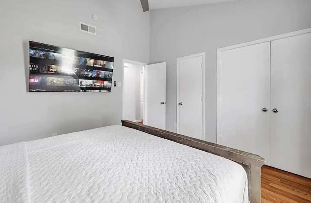 Hardwood-style flooring, white paneled doors, and light gray wall paint