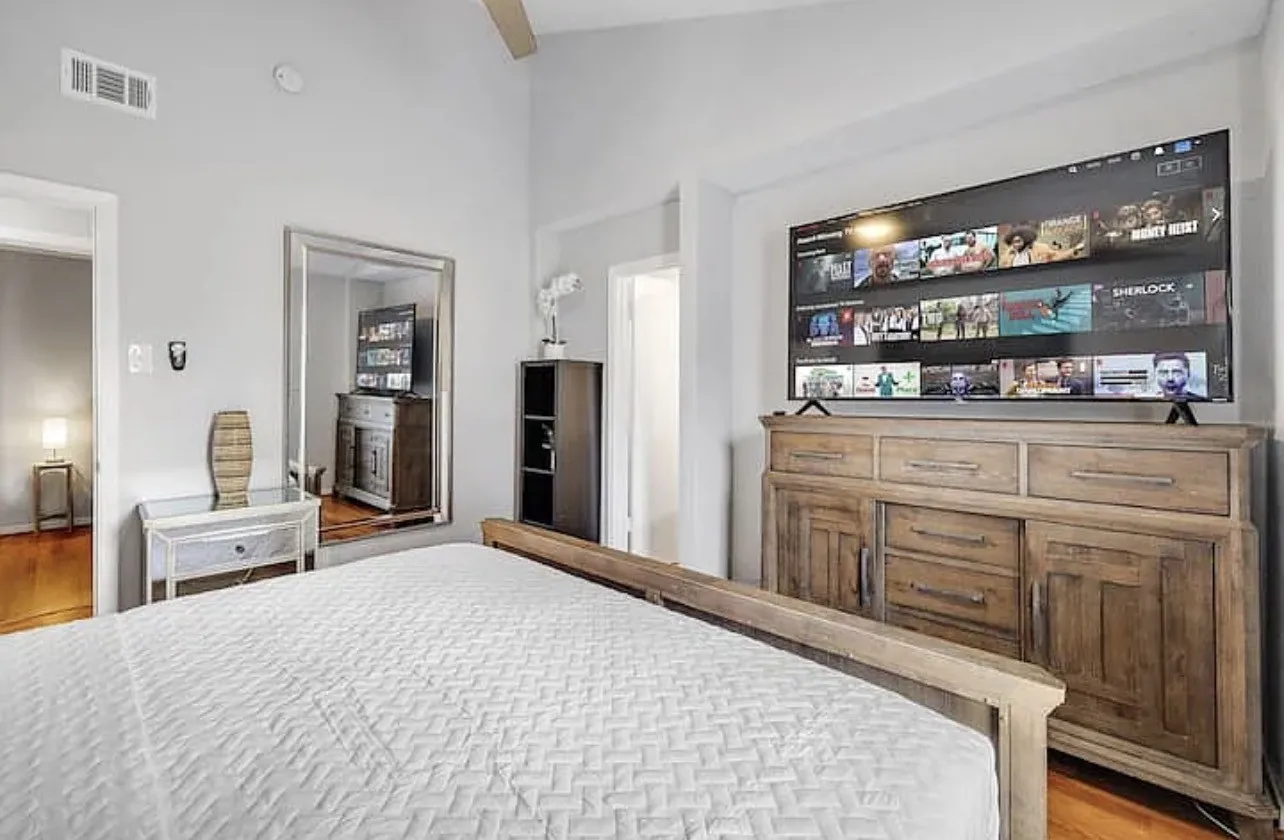 Vaulted ceiling with an exposed beam, light wood-finish flooring, and recessed lighting