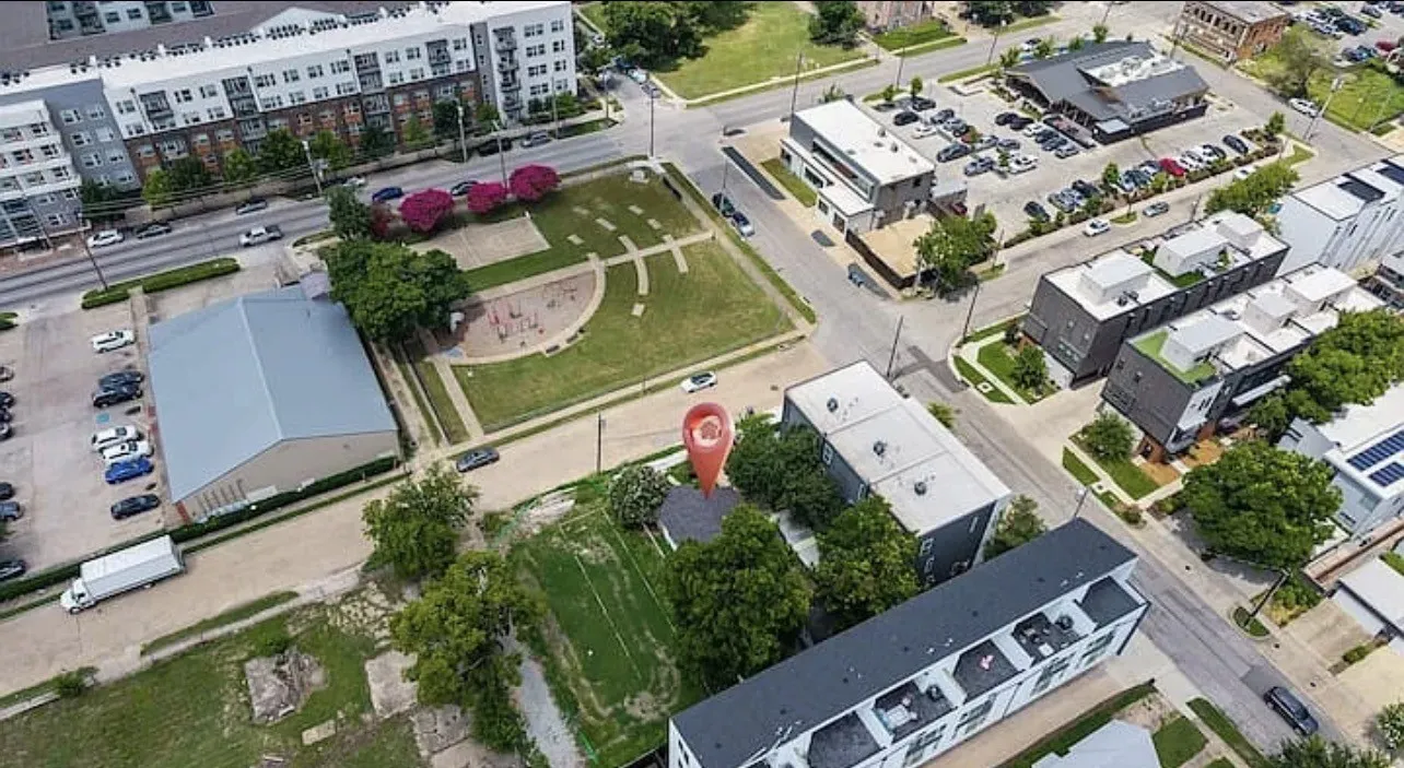 Aerial perspective showcasing the urban setting with surrounding residential structures and commercial buildings