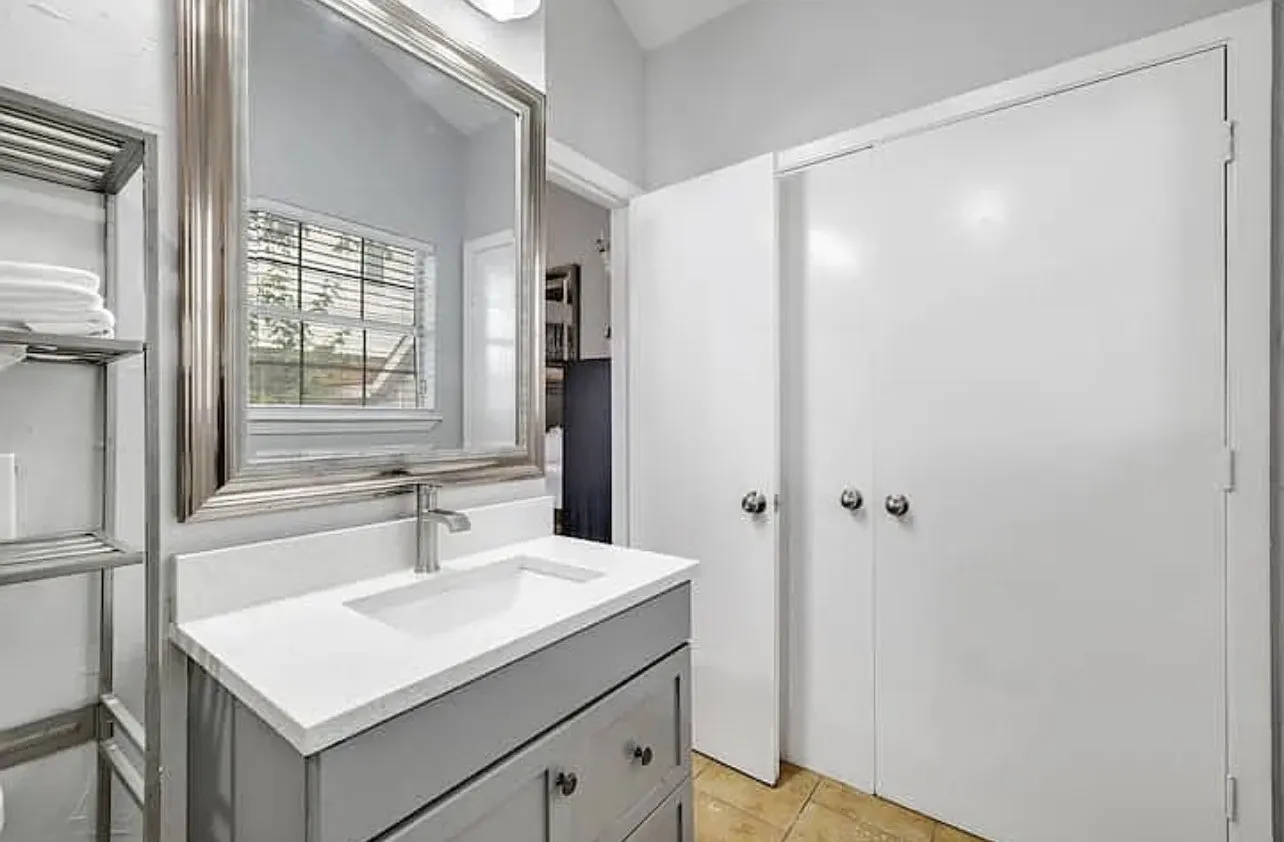 Vanity with a rectangular undermount sink, brushed nickel faucet, and a large framed mirror