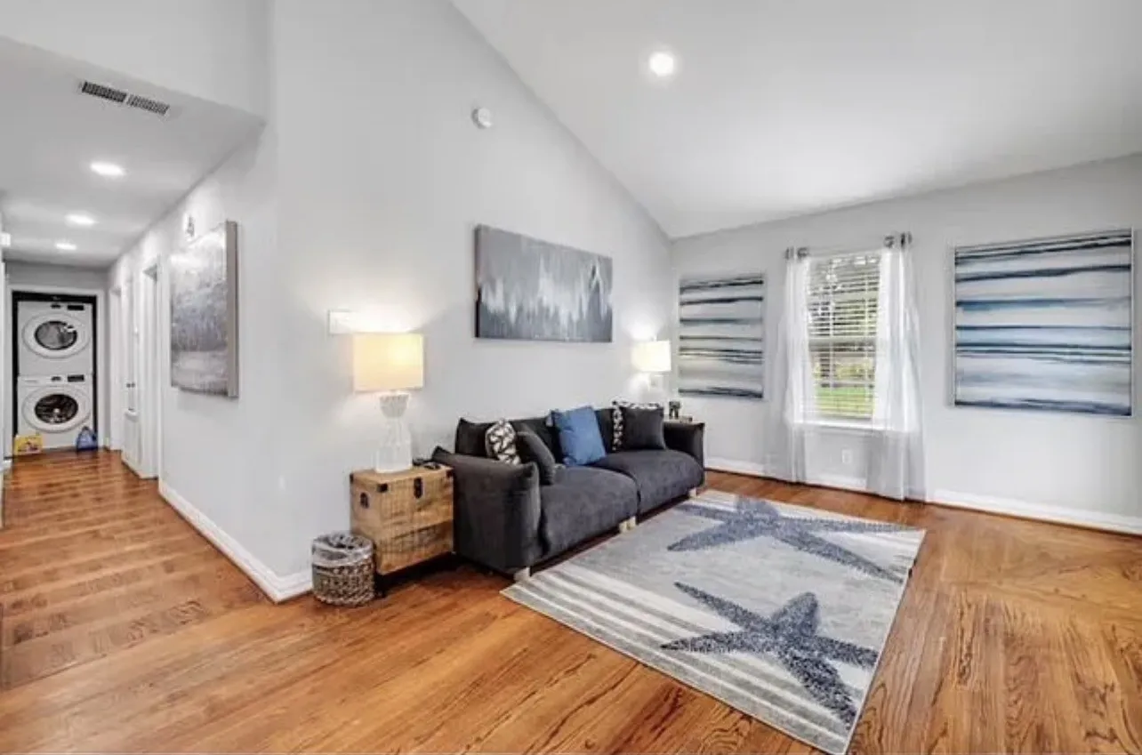 Wood-finish flooring throughout, vaulted ceiling, recessed lighting, and a window with blinds