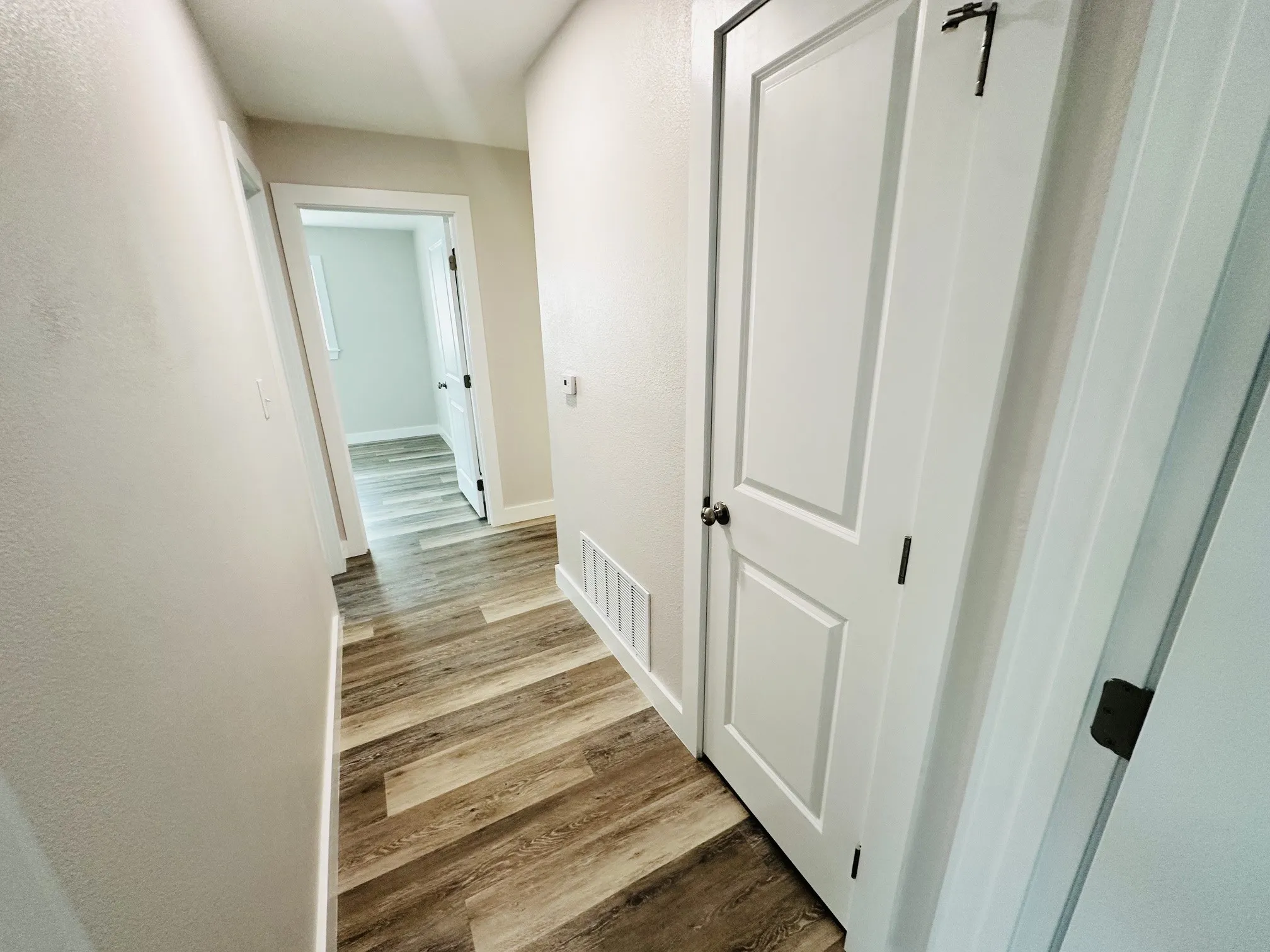 Wood-finish flooring throughout, white paneled doors, and light-toned walls