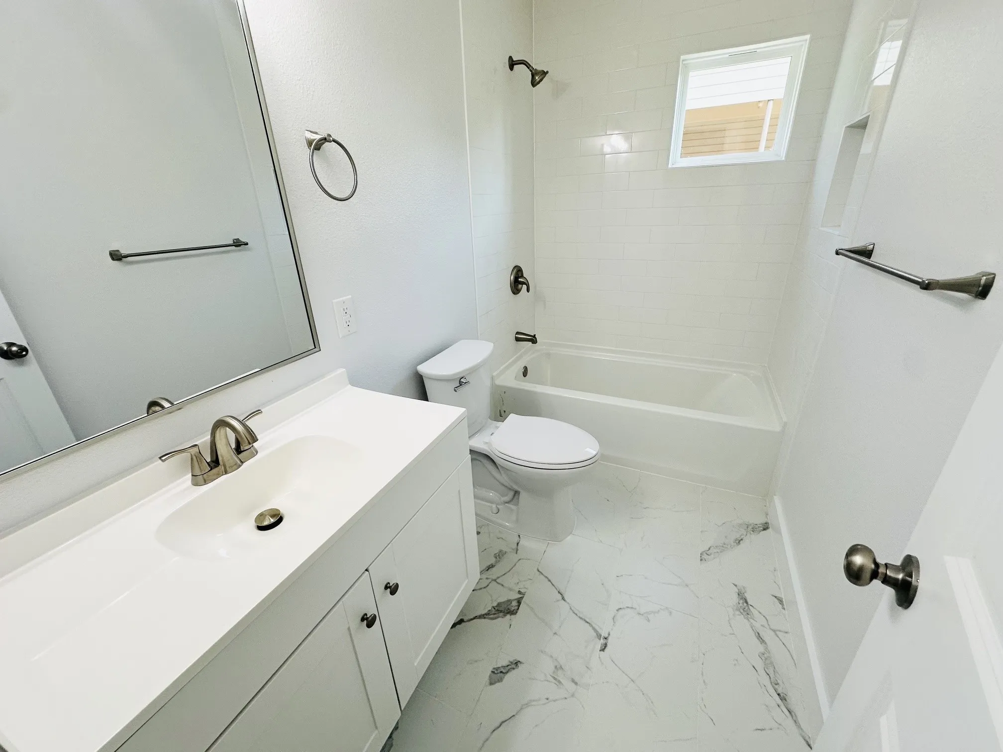 Vanity with integrated sink, sleek mirror, and modern brushed nickel hardware