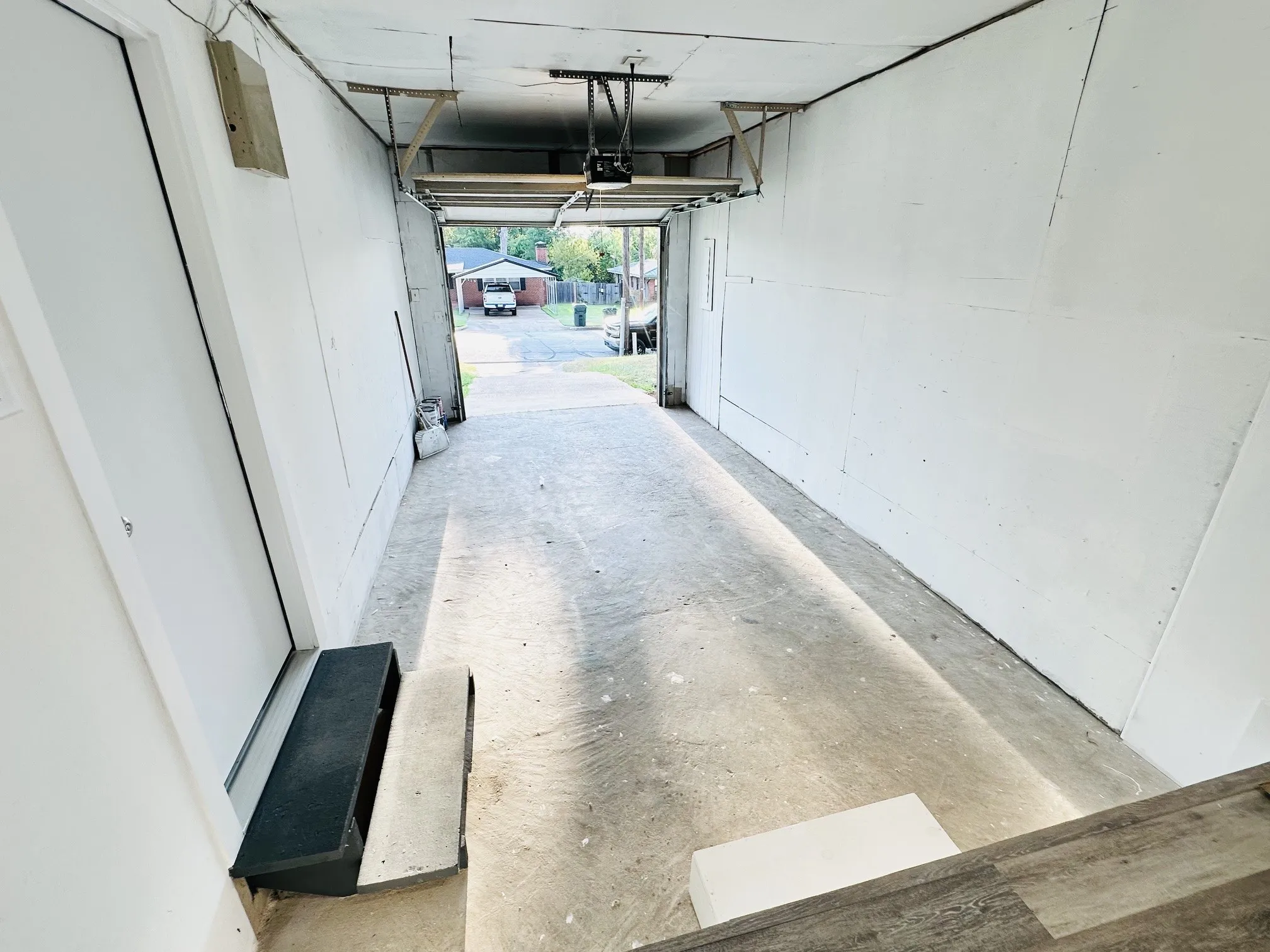 Attached garage with concrete flooring and a white overhead door